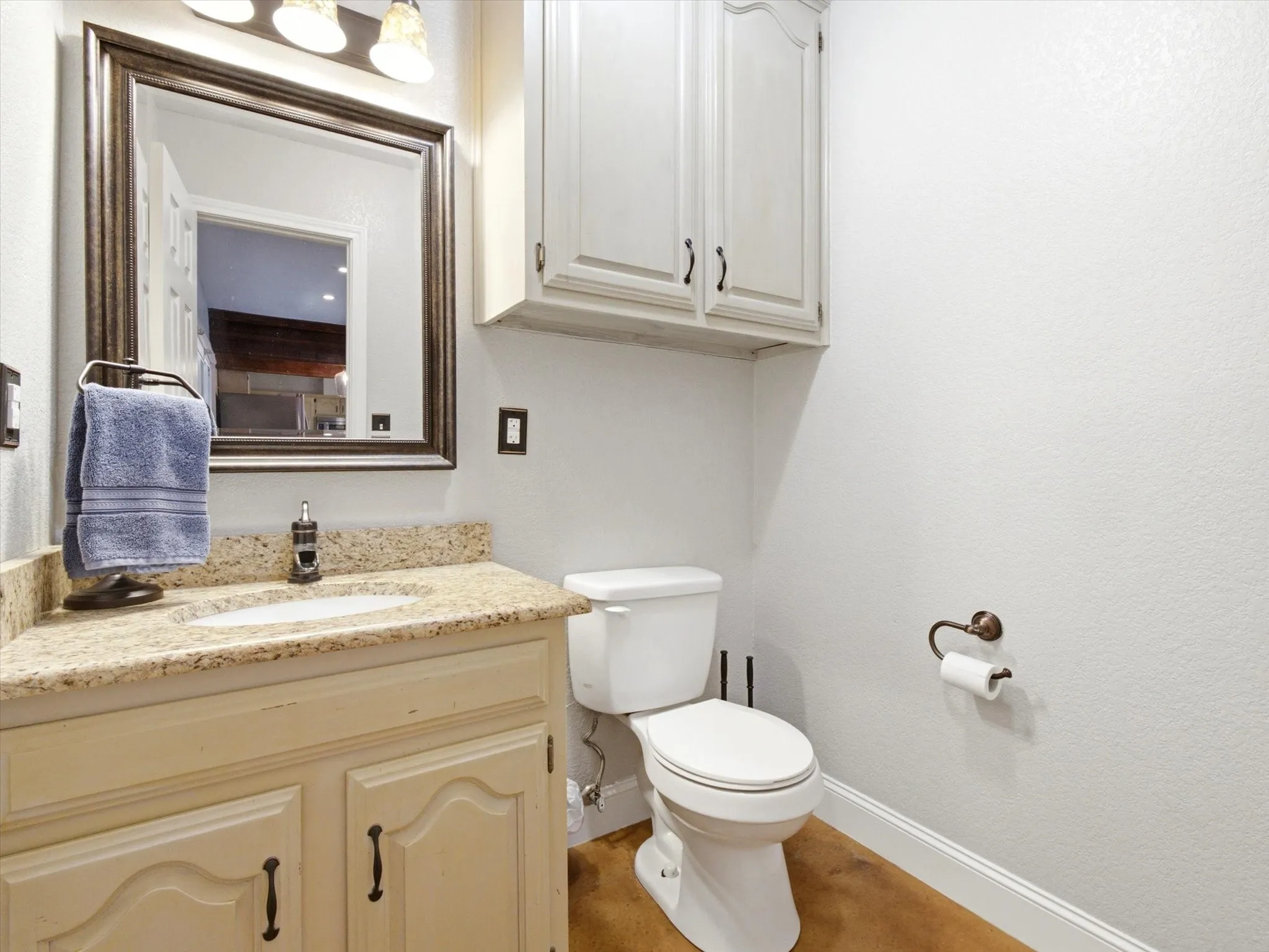 Bathroom featuring a vanity with a light-colored countertop, an undermount sink, and a framed mirror