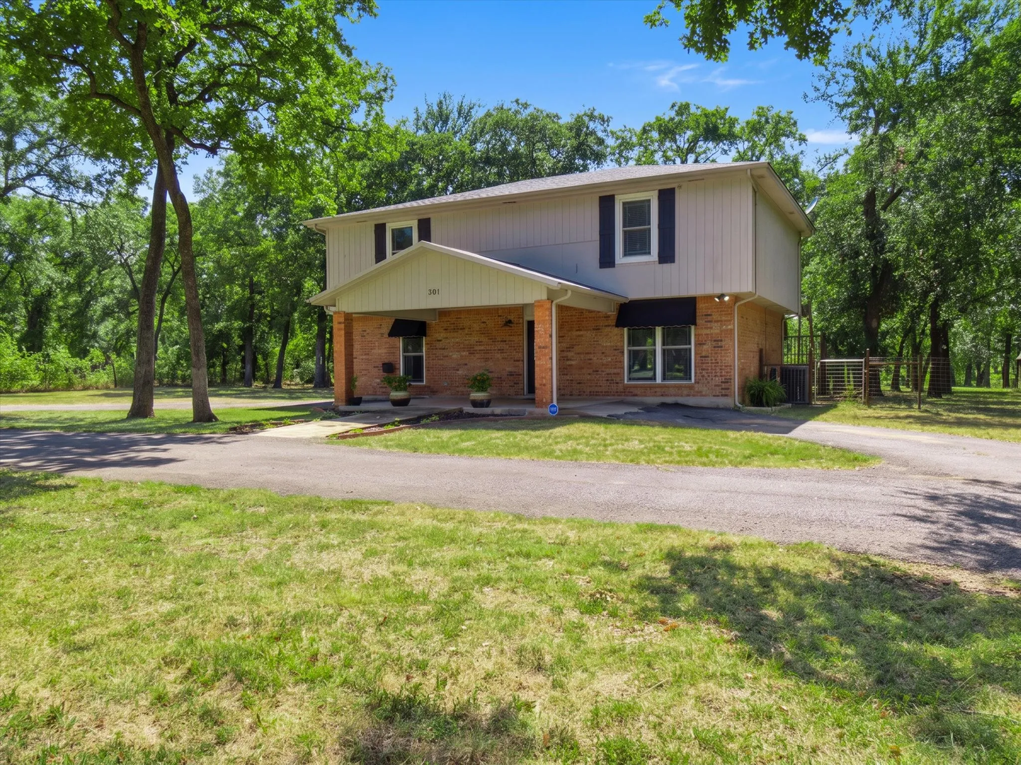 Two-story residence featuring a brick first story and light-colored siding on the second story