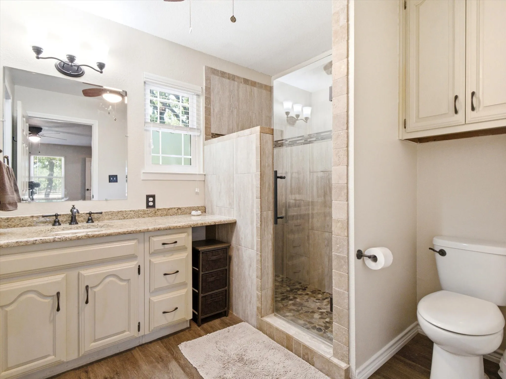 Bathroom featuring a glass-enclosed shower with pebble flooring and tiled walls