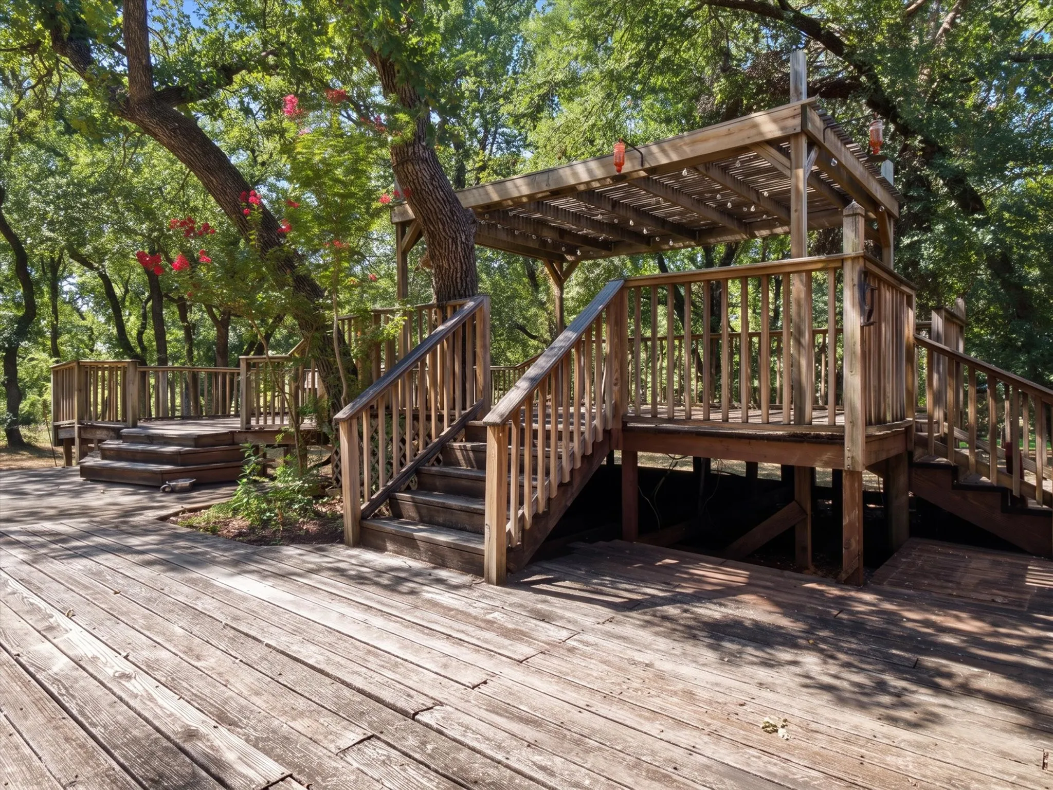 Expansive multi-level wood deck with natural wood railings, integrated stairs, and an overhead pergola structure