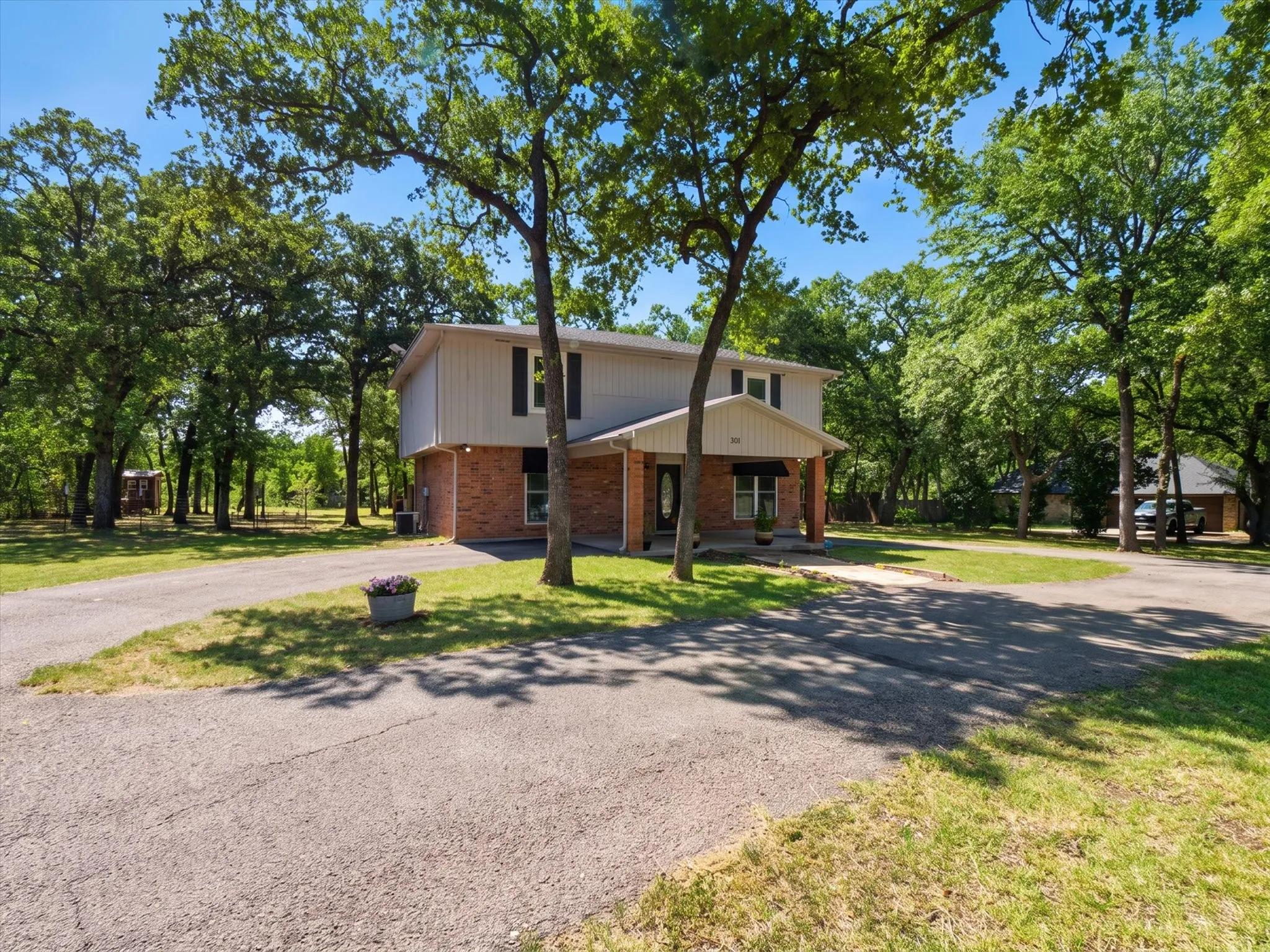 Two-story residence featuring a brick first level and light-colored siding on the second level