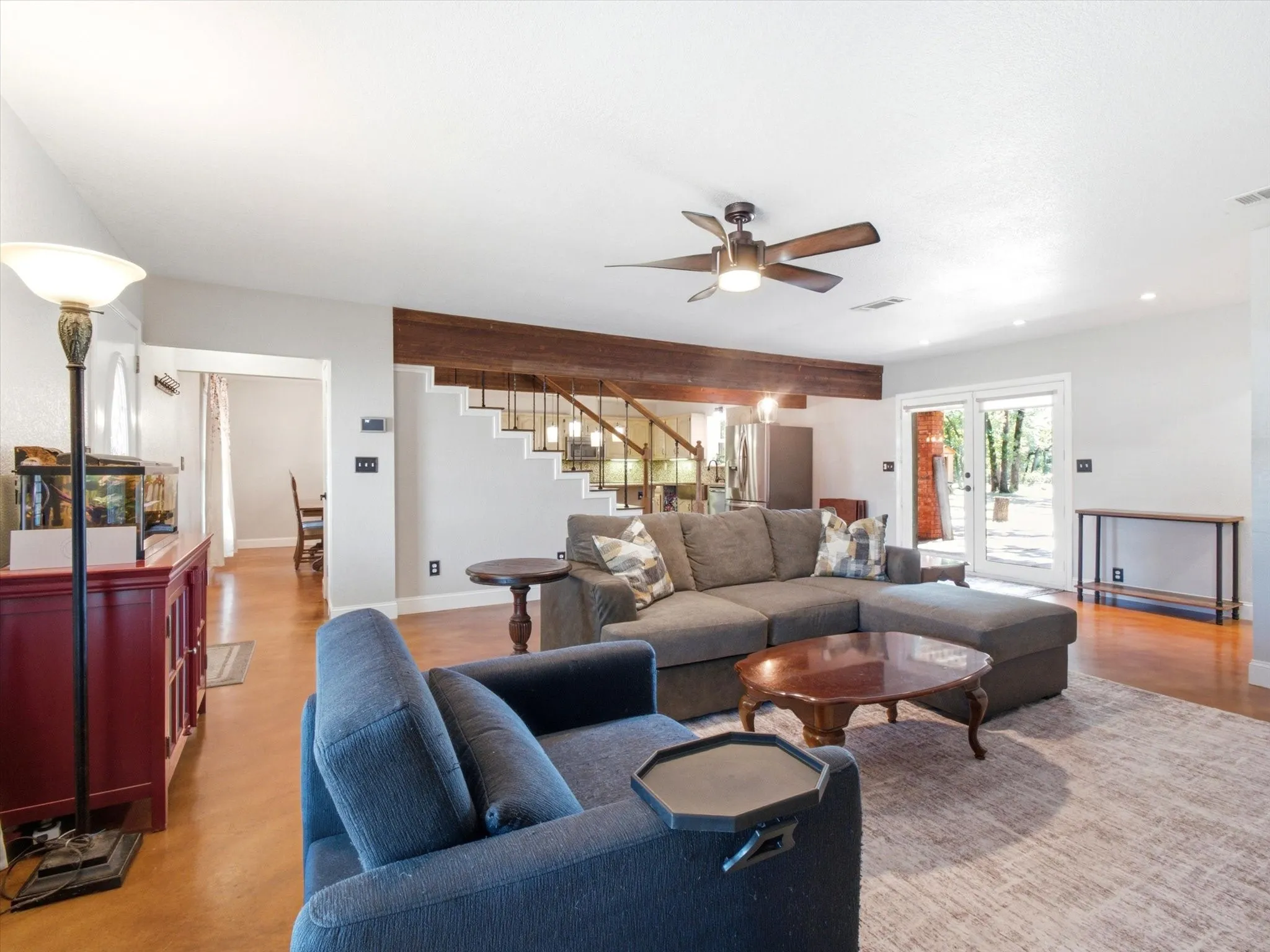 Spacious living area featuring polished concrete flooring, a wood-beam accent, a ceiling fan, and recessed lighting