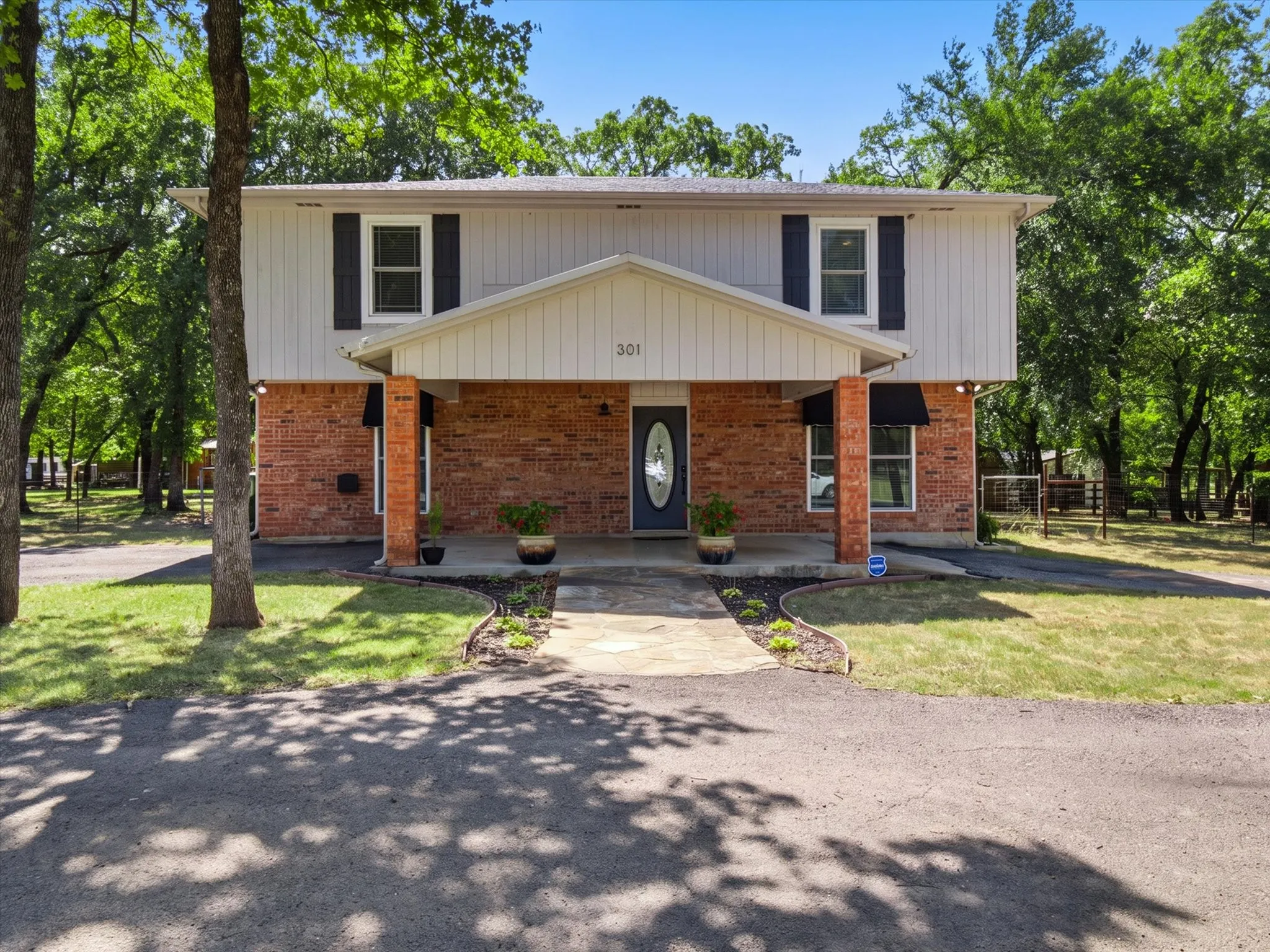 Two-story residence featuring a brick first level and light-colored siding on the second