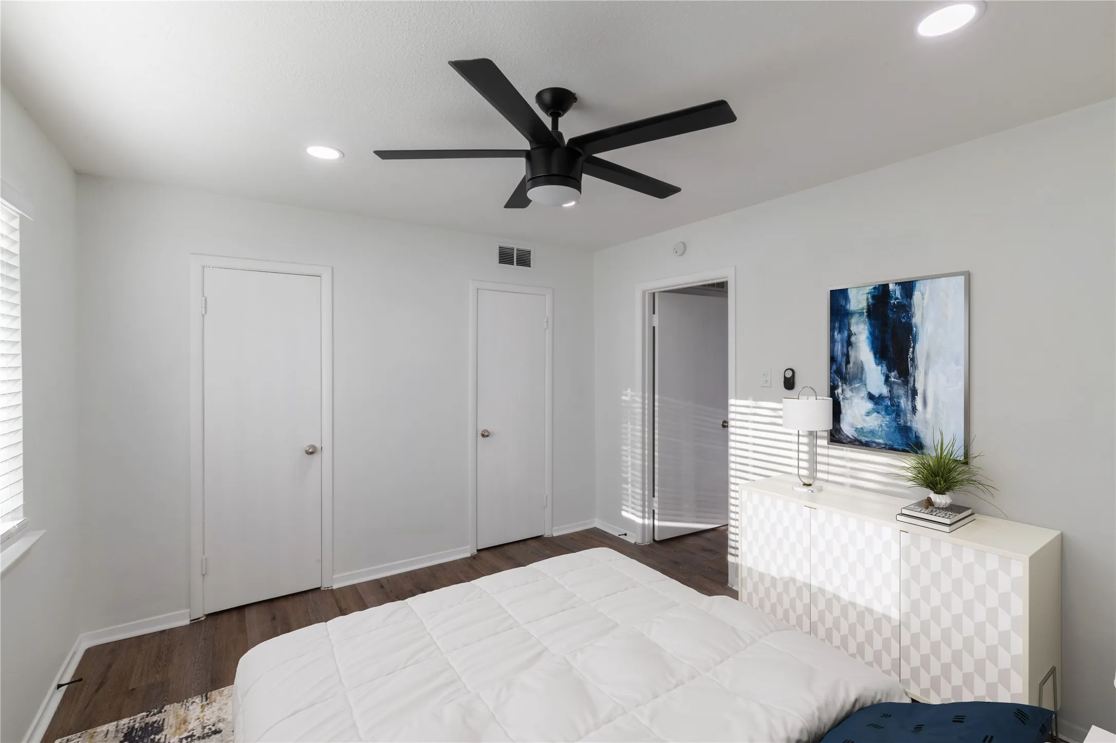 Bright room featuring wood-finish flooring, recessed lighting, and a modern ceiling fan