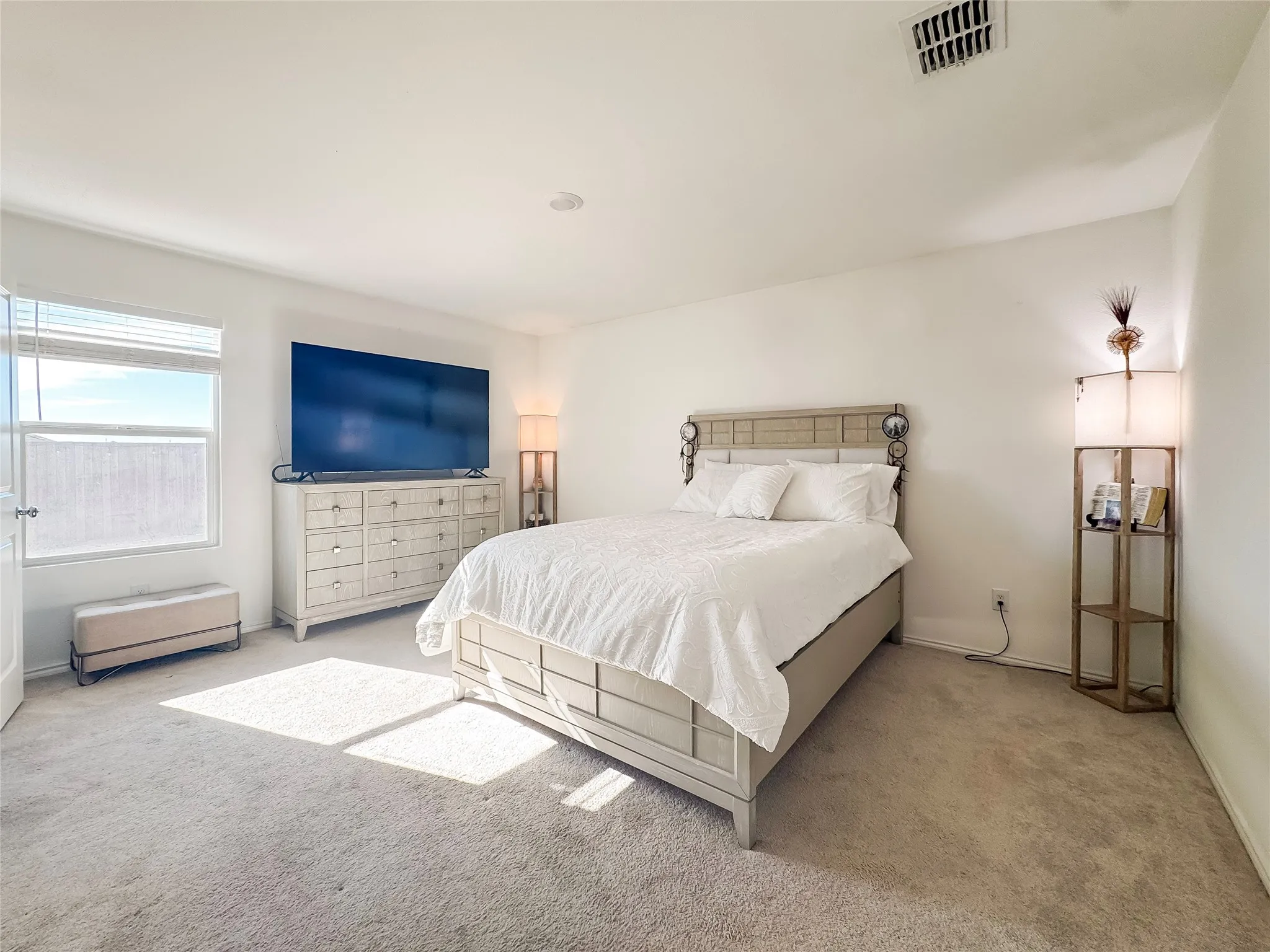 Carpeted bedroom with a single window featuring horizontal blinds