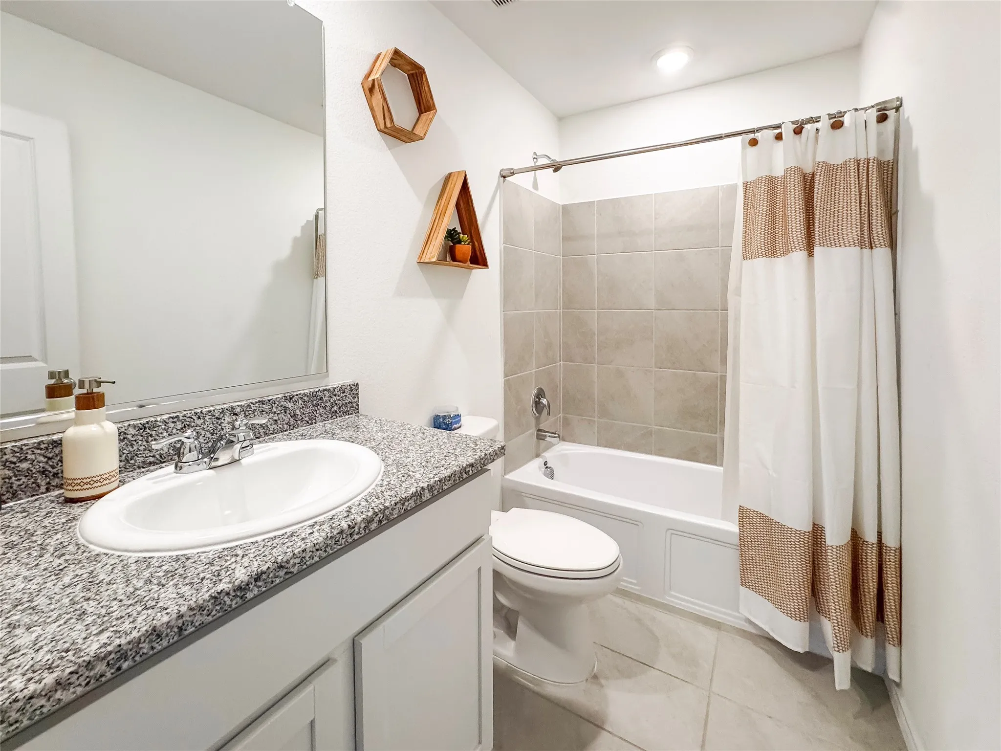 Bathroom featuring a white vanity with a granite countertop, integrated sink, and chrome faucet