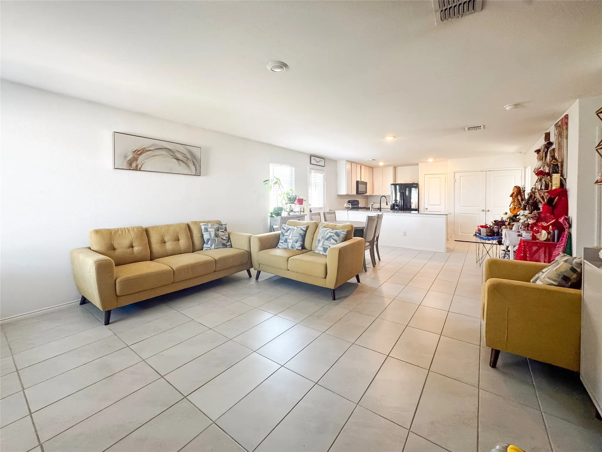 Expansive living area featuring light-toned tile flooring throughout