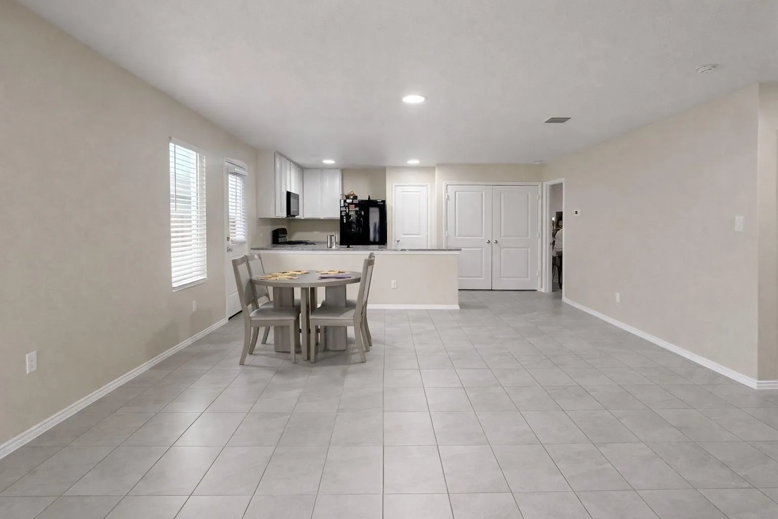Open-concept living area with light-toned tiled flooring