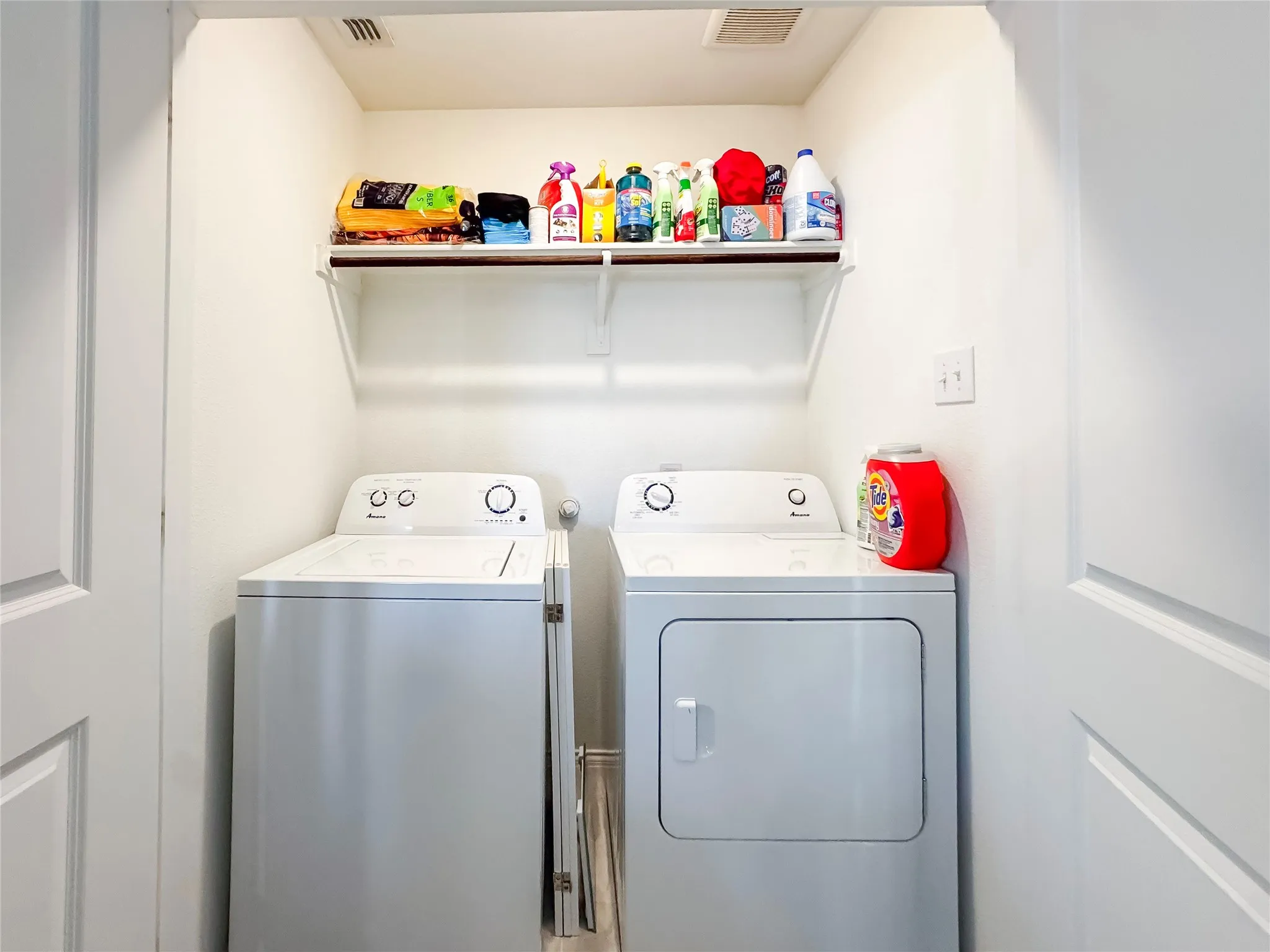 Dedicated laundry area featuring a white top-load washing machine and front-load dryer