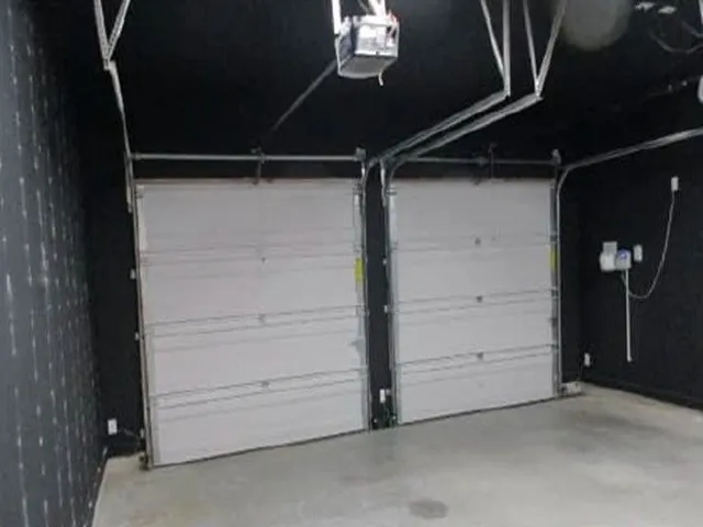 Two white sectional garage doors with overhead track systems