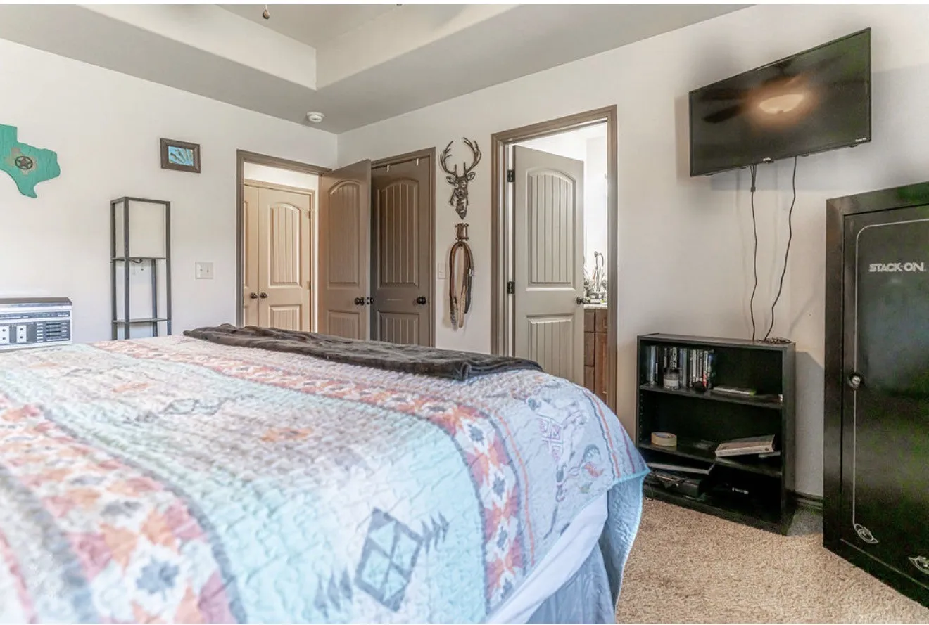 Recessed tray ceiling with ceiling fan, neutral wall paint, and carpeted flooring
