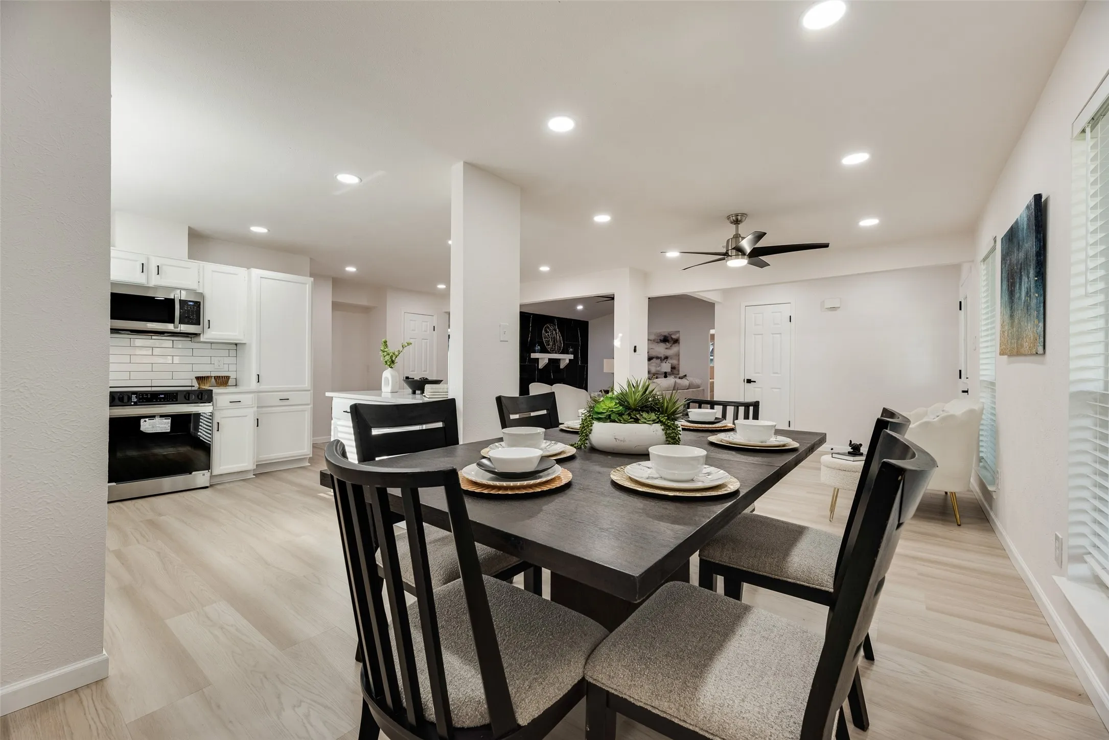 Open-concept dining area featuring light wood-finish flooring and recessed lighting