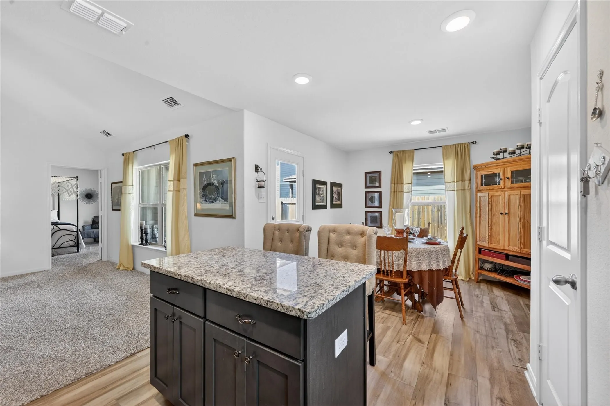 Kitchen island with a granite-style countertop and dark wood-finish cabinetry