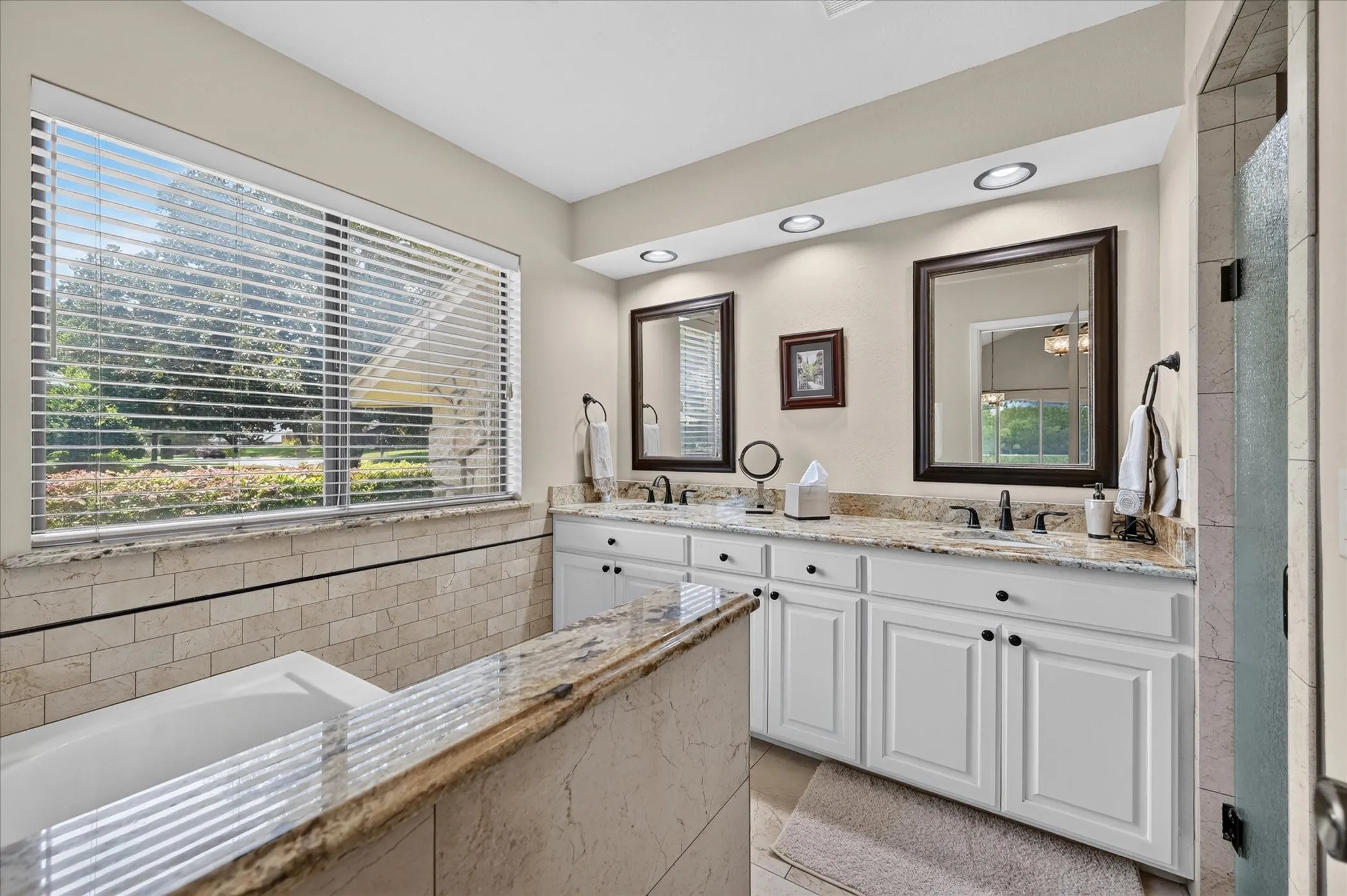 Updated primary bath with granite, tub, paint, lighting, shower, & tile walls & floors!