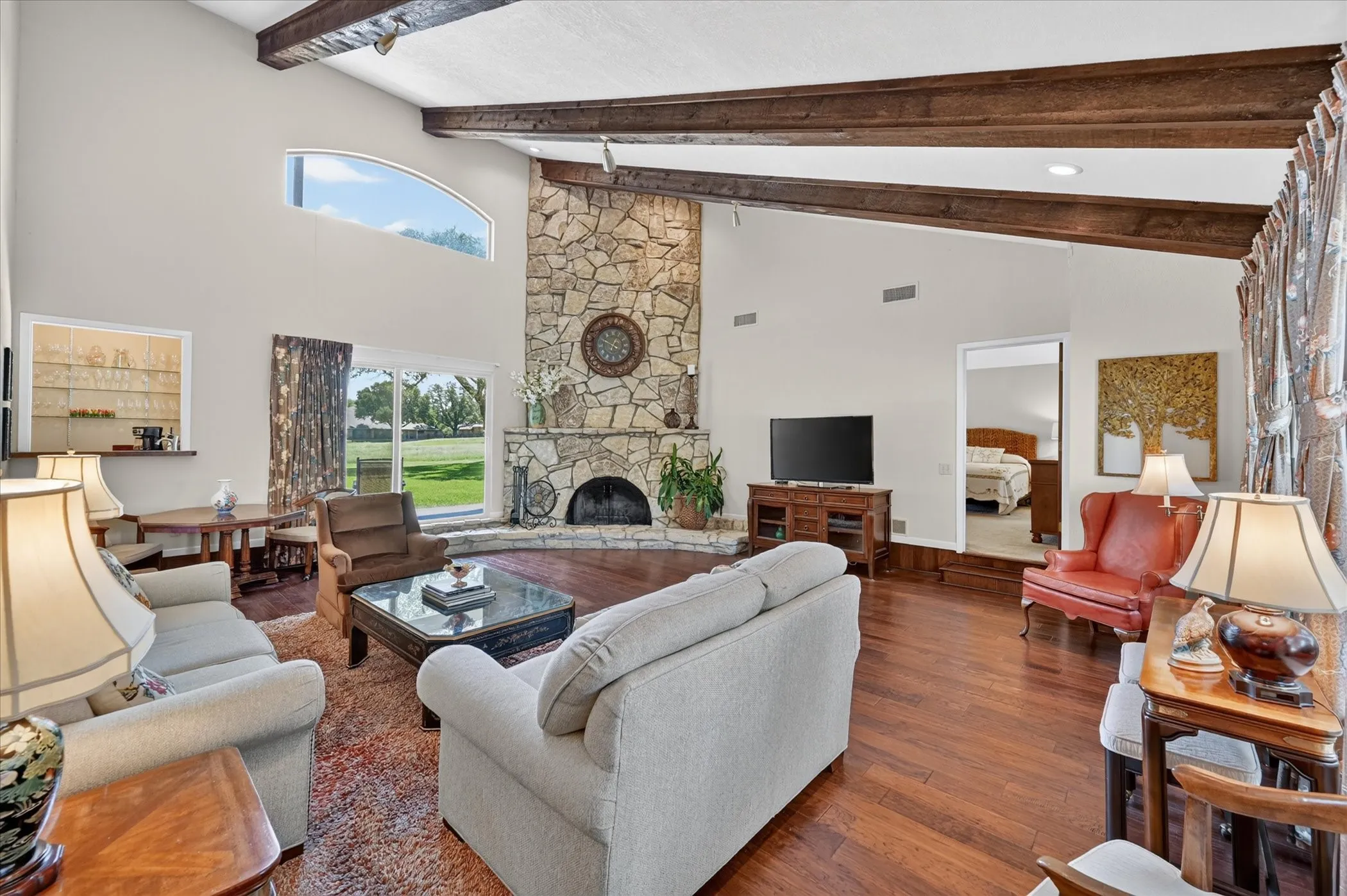 Spacious living area, with wood floors, vaulted ceilings, stone fireplace, light & right! Wet Bar with storage! Views to the backyard & greenbelt!