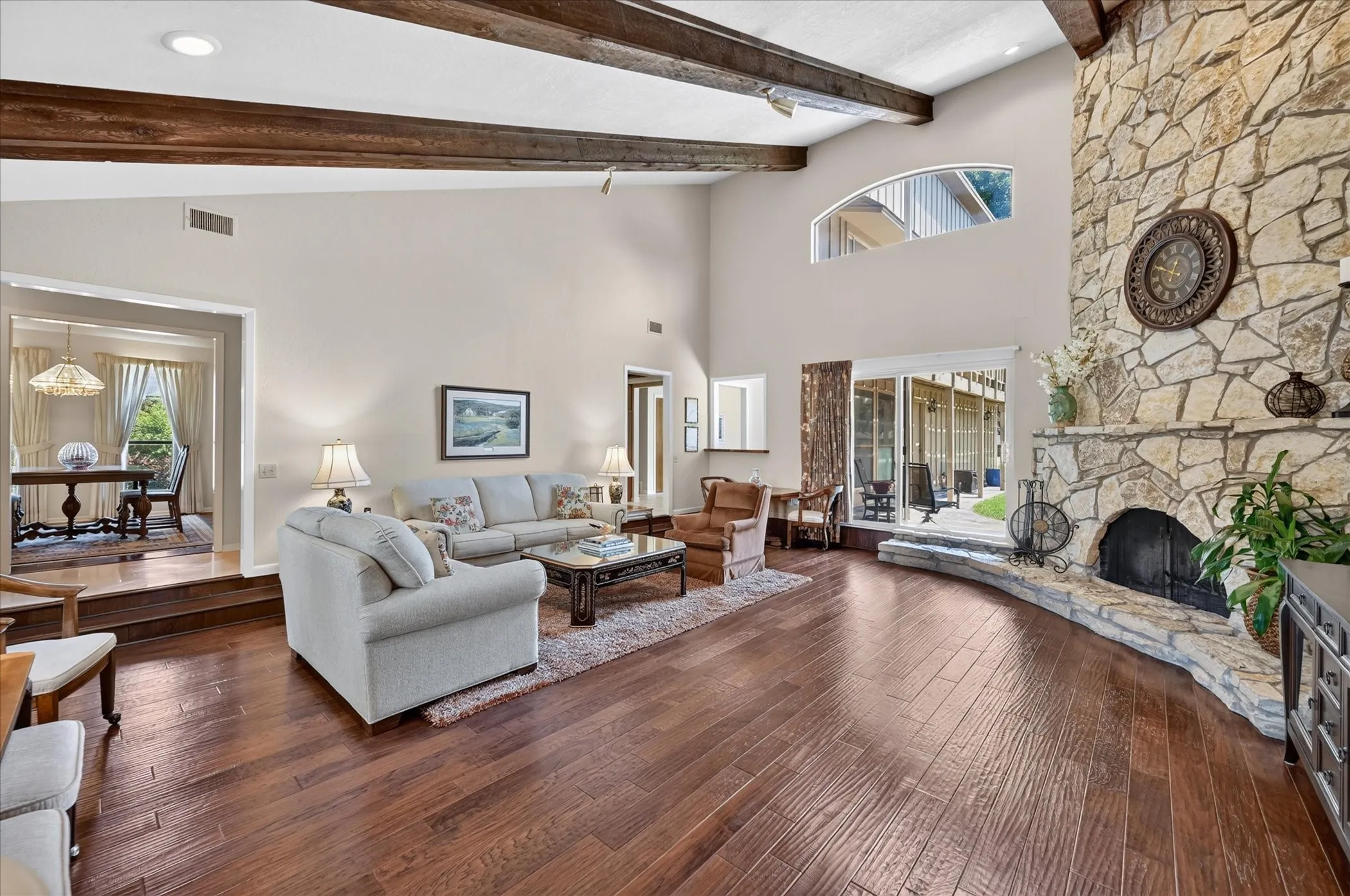 Another view of this fabulous living area, rich wood floors, stone fireplace, vaulted ceilings with wood beams!