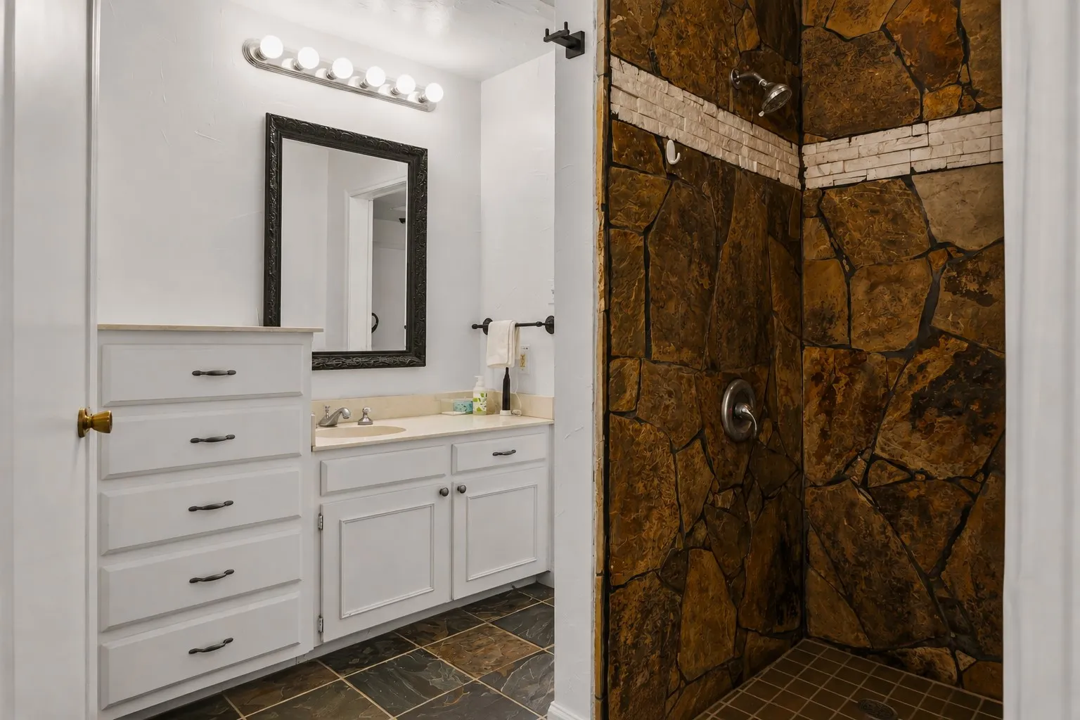 Floor-to-ceiling natural stone shower with accent tiling
