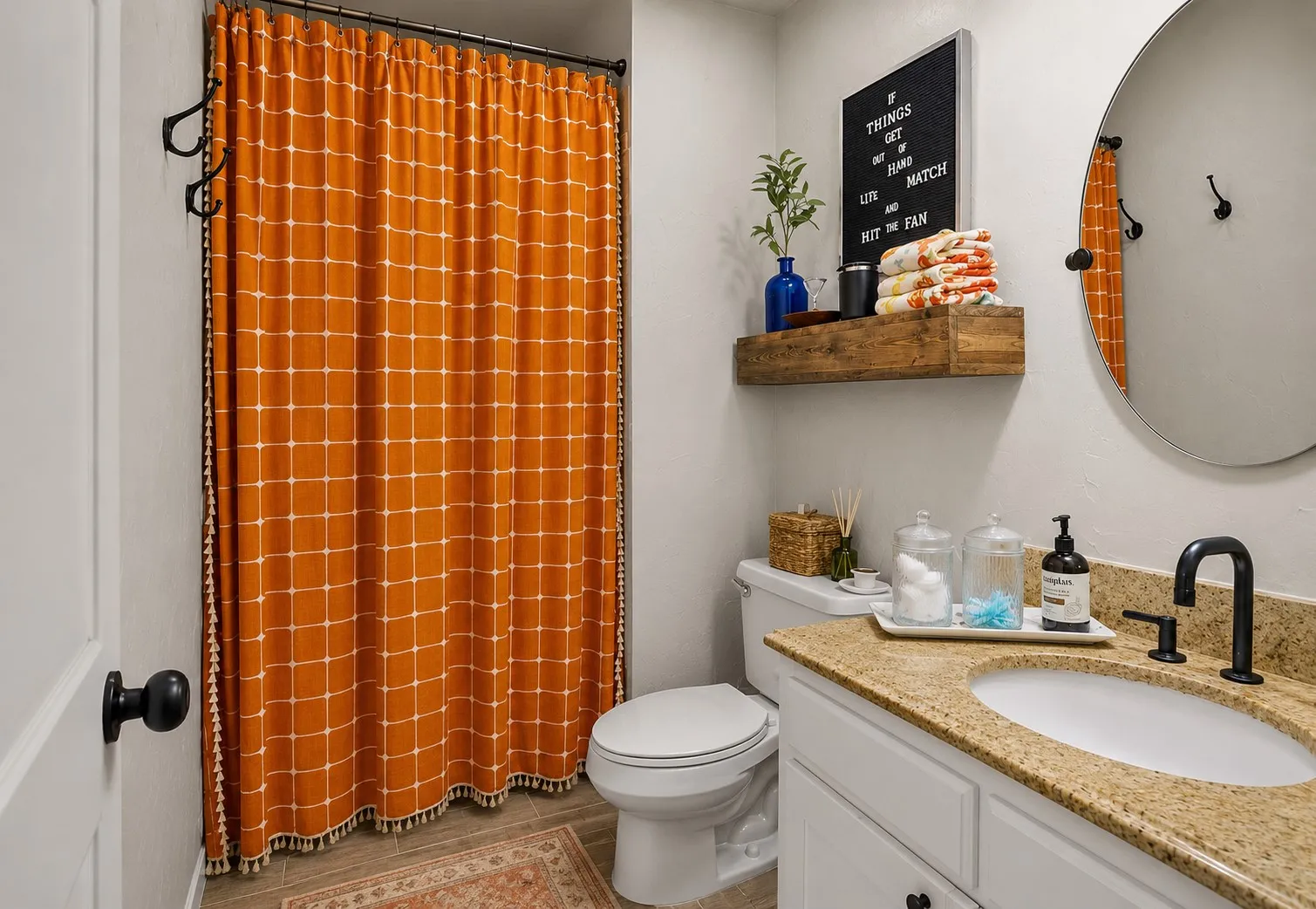 White vanity with a granite countertop, undermount sink, and matte black faucet