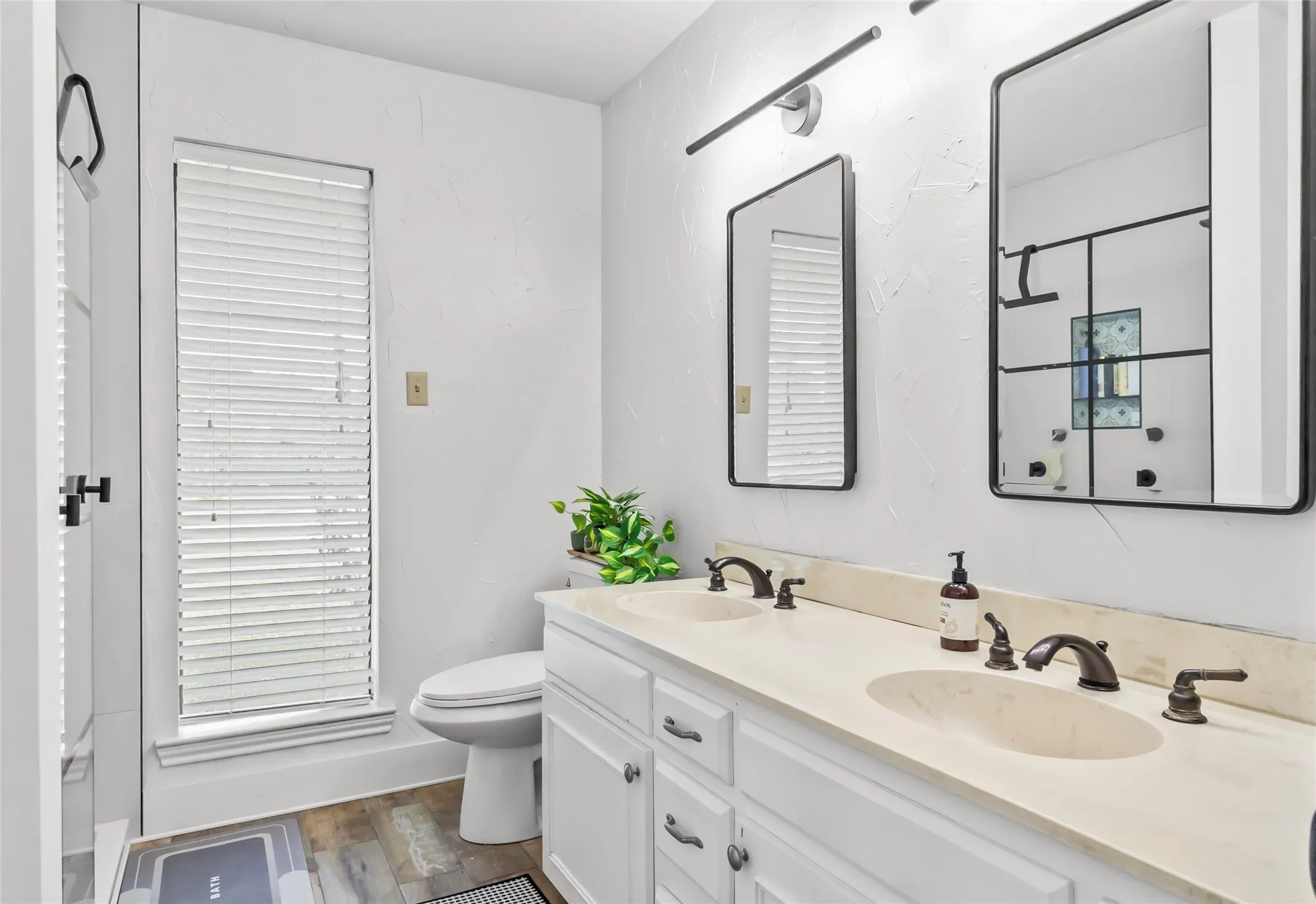 Dual vanity with undermount sinks, white cabinetry, and bronze-finish fixtures