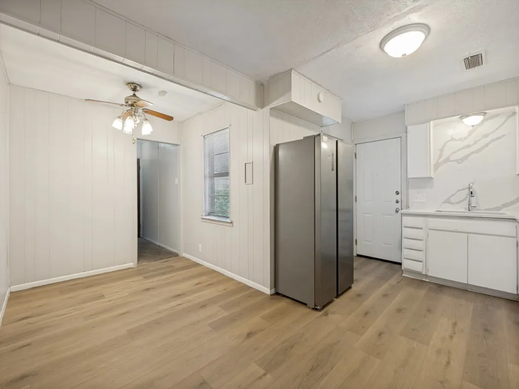 Vinyl plank flooring throughout eat in kitchen dining area with bright kitchen and window