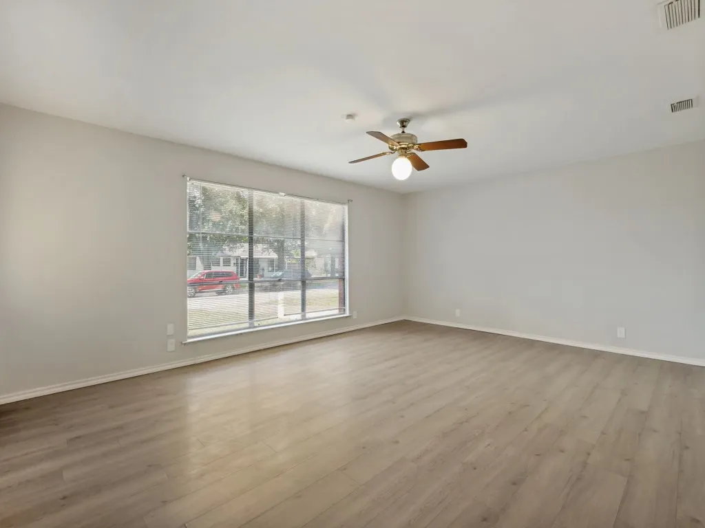 Oversized living area with vinyl plank flooring and natural light through large front window