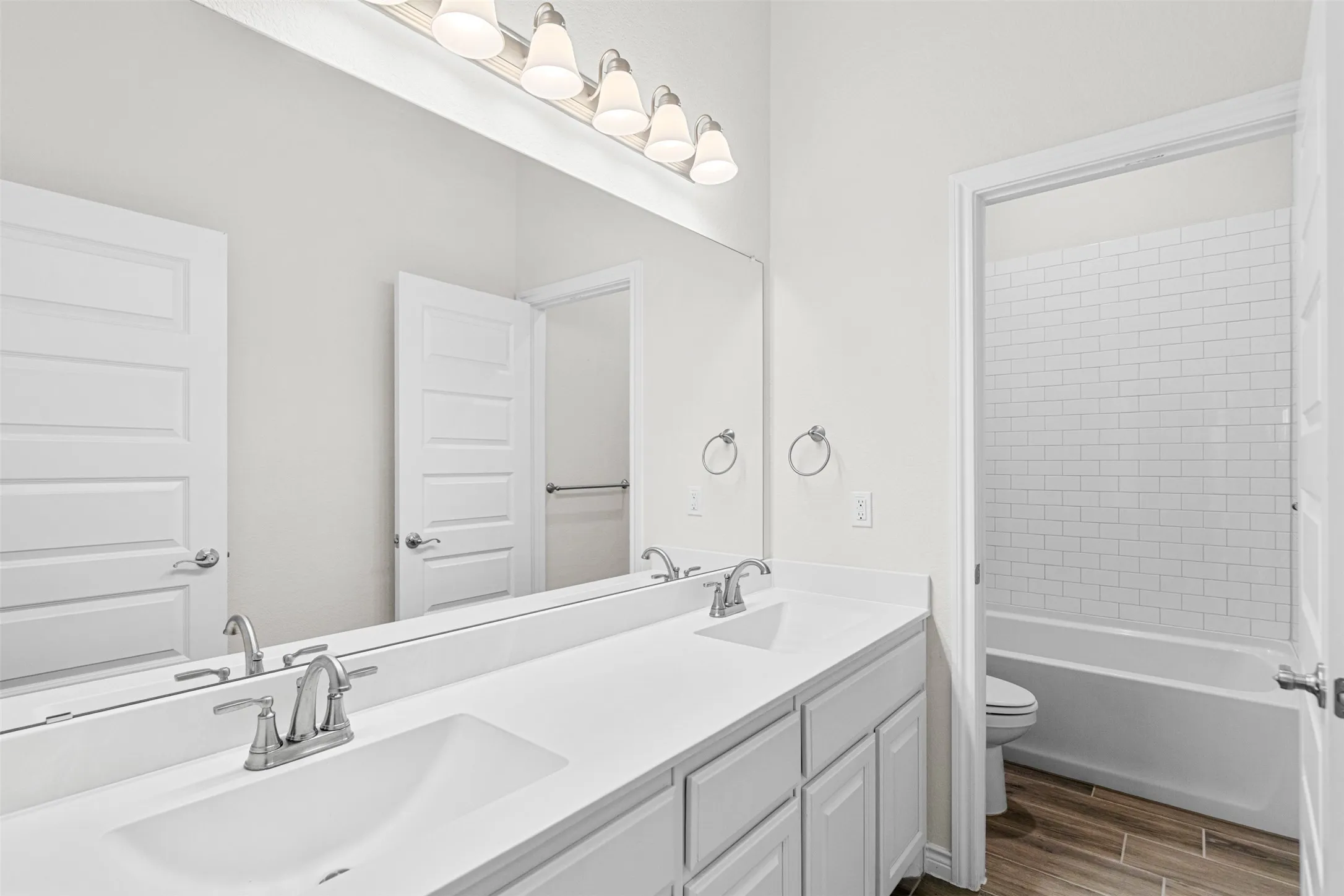 Dual-sink vanity with white quartz countertops, chrome faucets, and gray cabinetry
