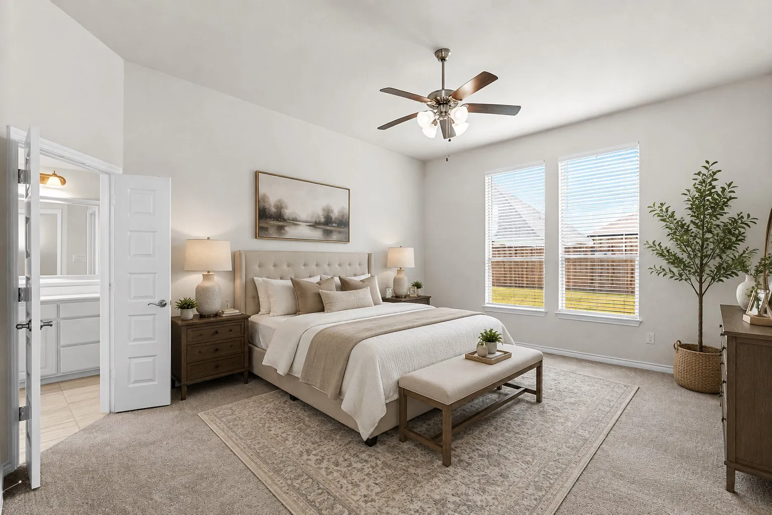 Spacious primary bedroom showcasing a neutral upholstered bed frame, dual nightstands with integrated lighting, ceiling fan with brushed metal finish, and large glass doors providing natural light