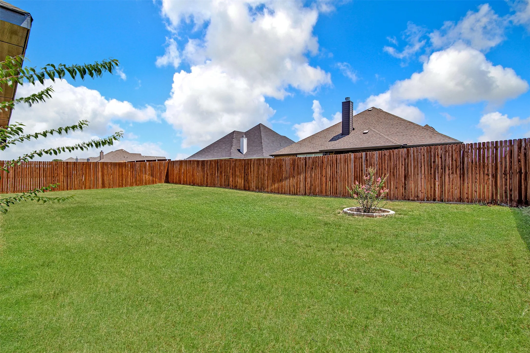 Expansive lawn area with a perimeter wood fence