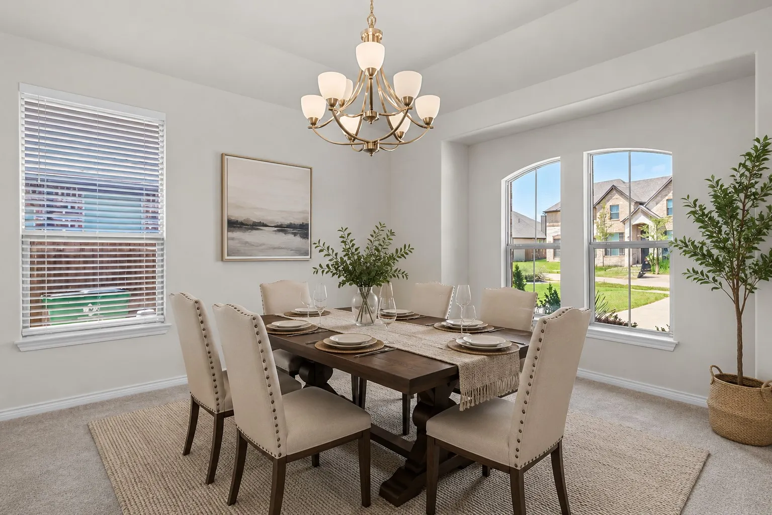 Dining area featuring a brass chandelier, a rectangular window with blinds, and two arched windows