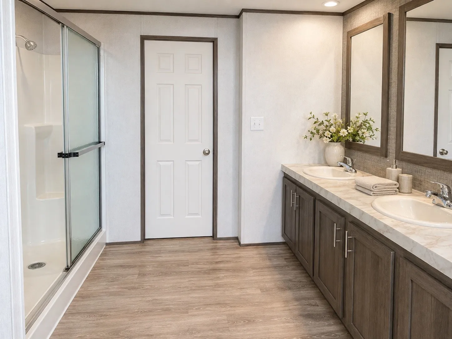 Bathroom featuring a double vanity with integrated sinks, wood-finish cabinetry, and framed mirrors