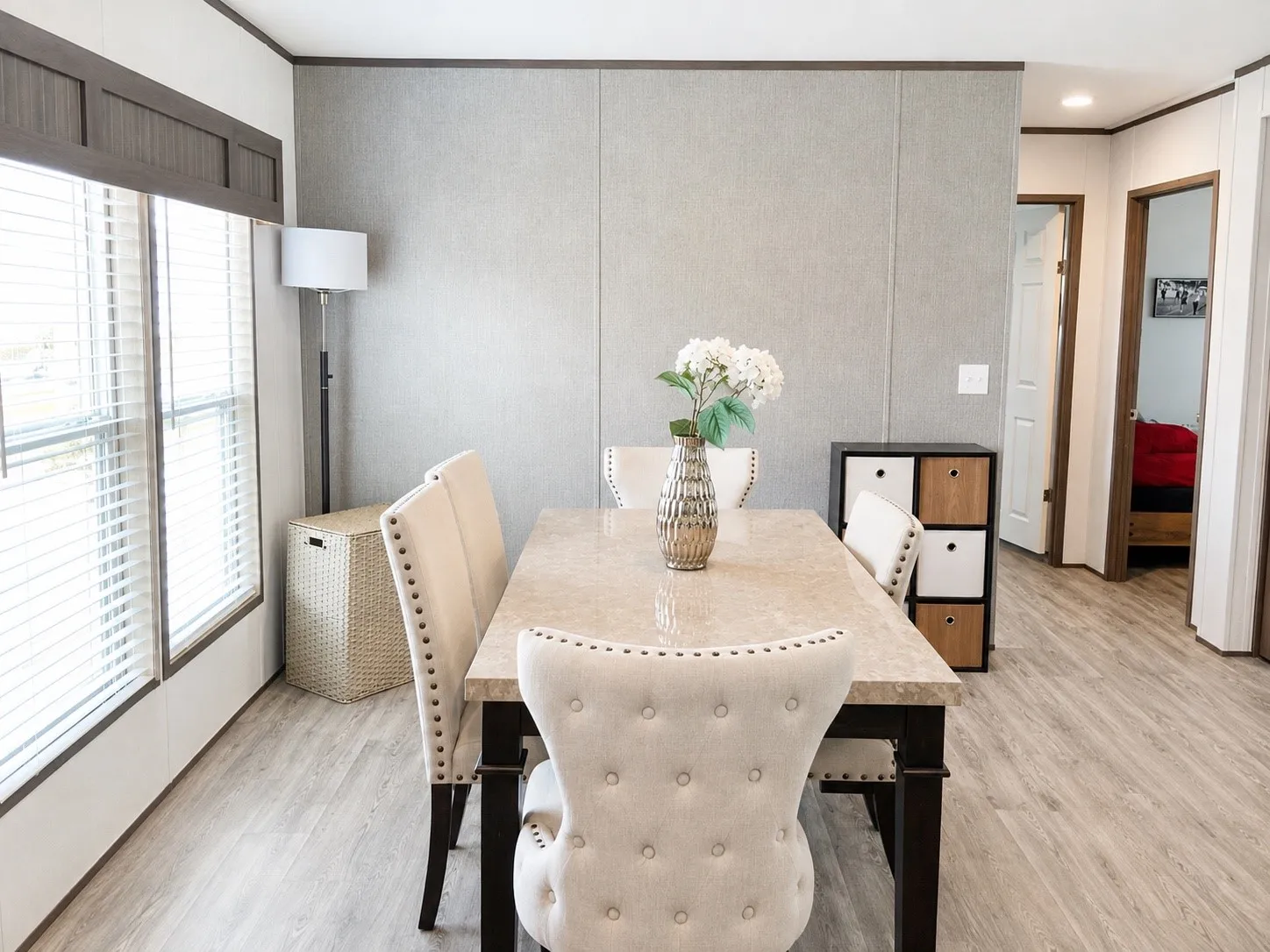 Dining area featuring wood-finish flooring, two large windows with blinds, and paneling on the walls