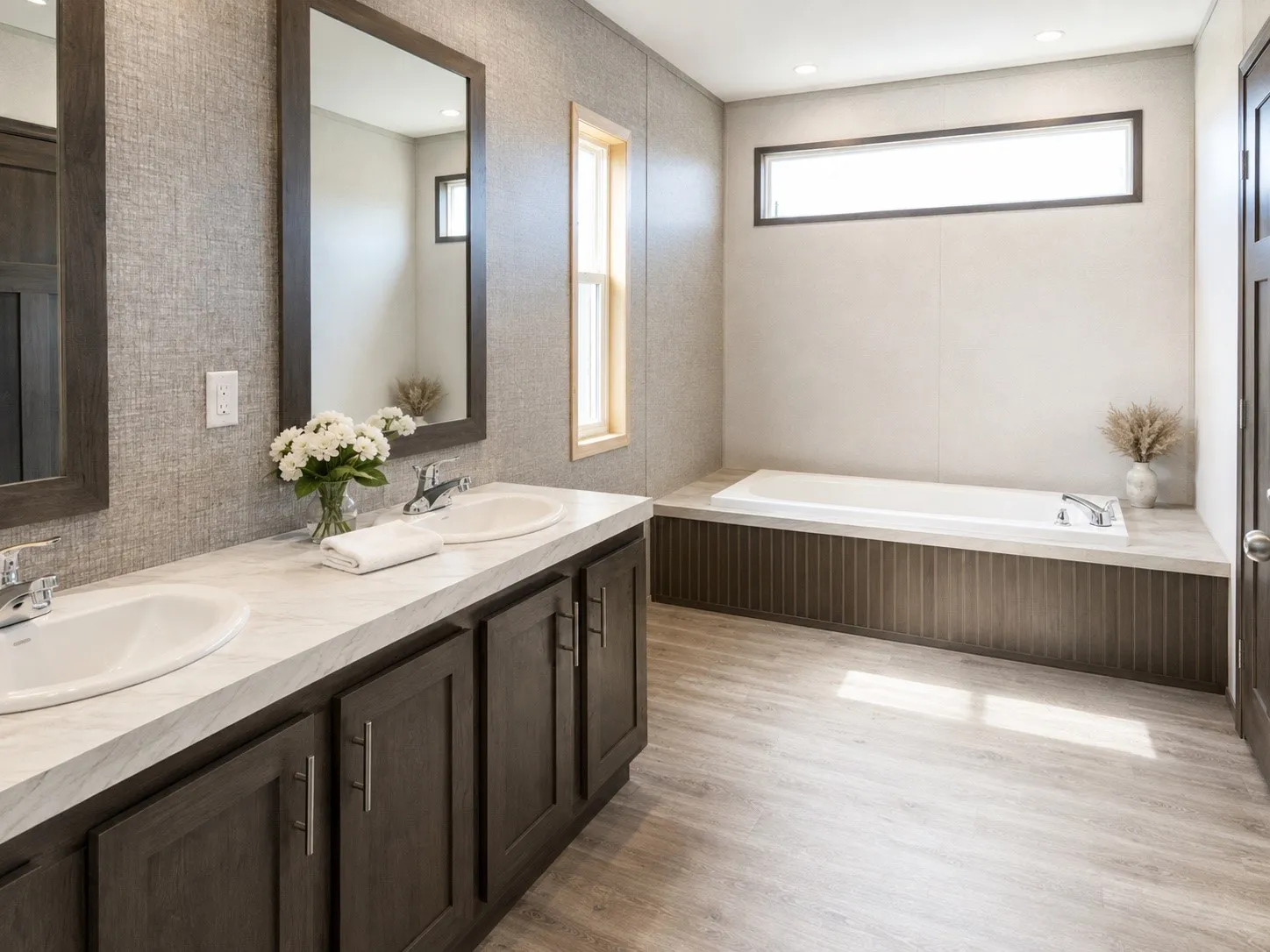 Double vanity with integrated sinks and dark wood-finish cabinetry