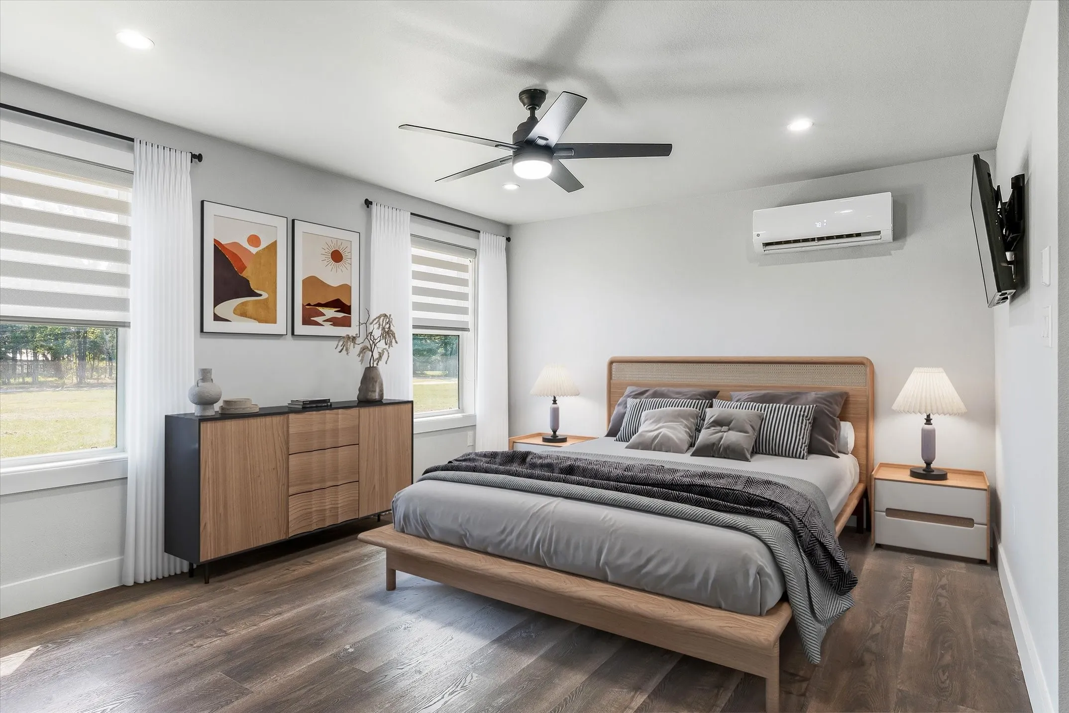 Digitally enhanced. Spacious room with wood-finish flooring, multiple windows with blinds, a ceiling fan, and a wall-mounted AC unit