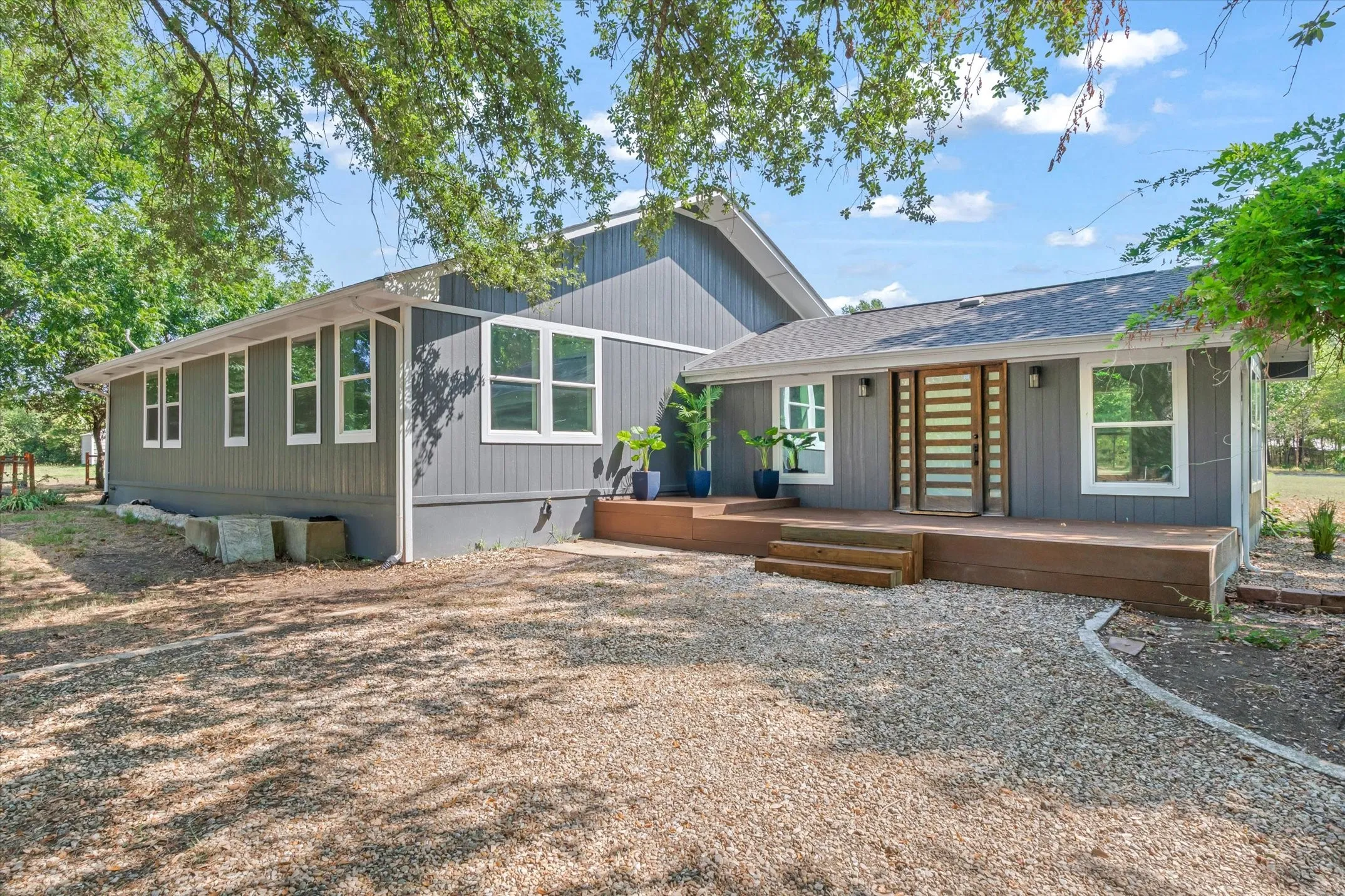 Contemporary gray exterior with white trim and a prominent front deck