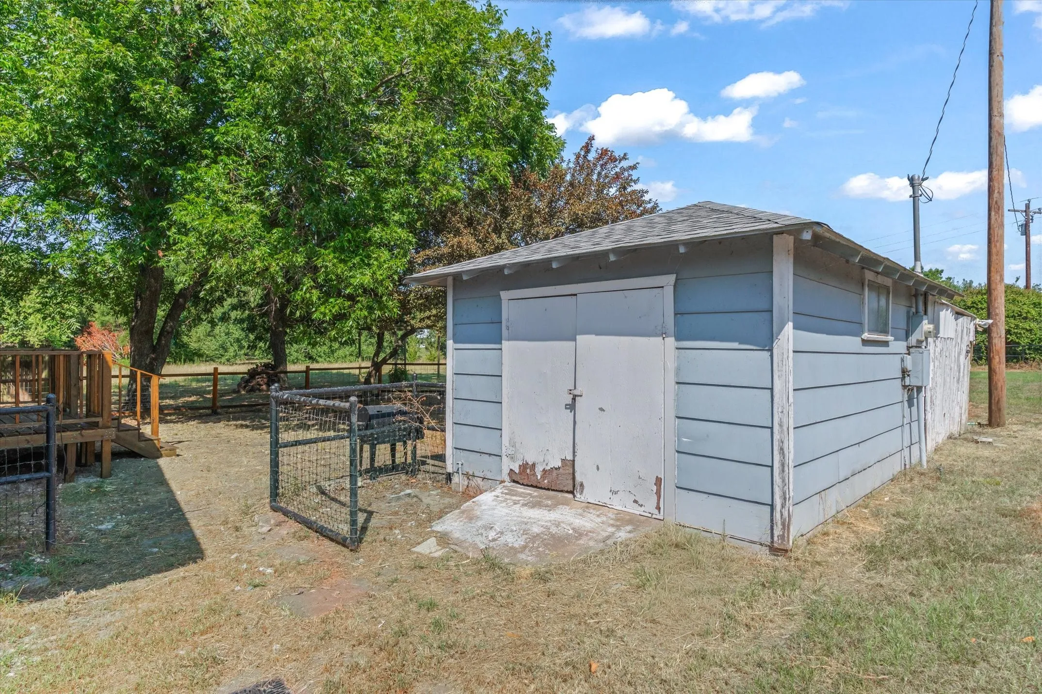 Detached outbuilding with light blue siding