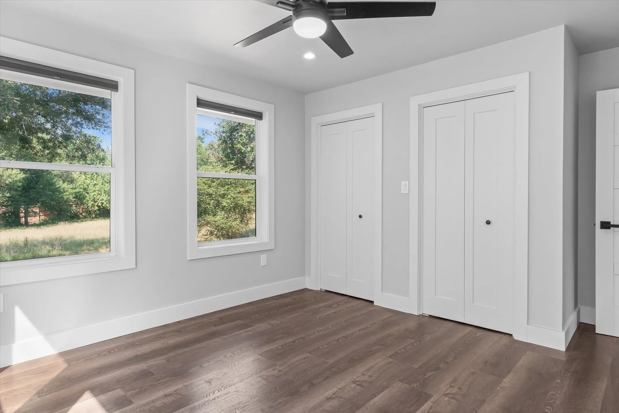 Spacious room featuring wood-finish flooring and a ceiling fan