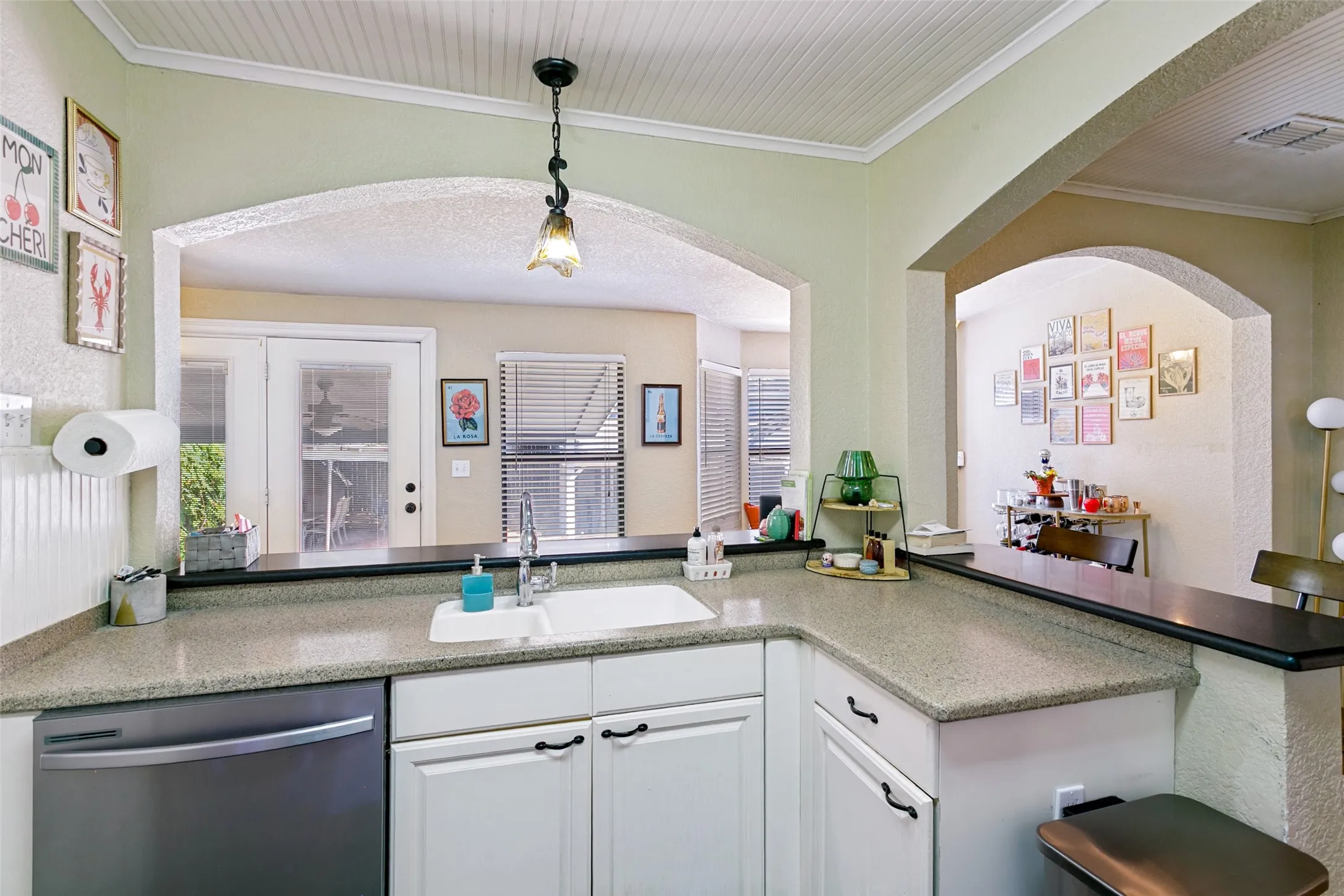 Here you can see the stainless dishwasher, solid surface countertop and the door leading to the backyard.