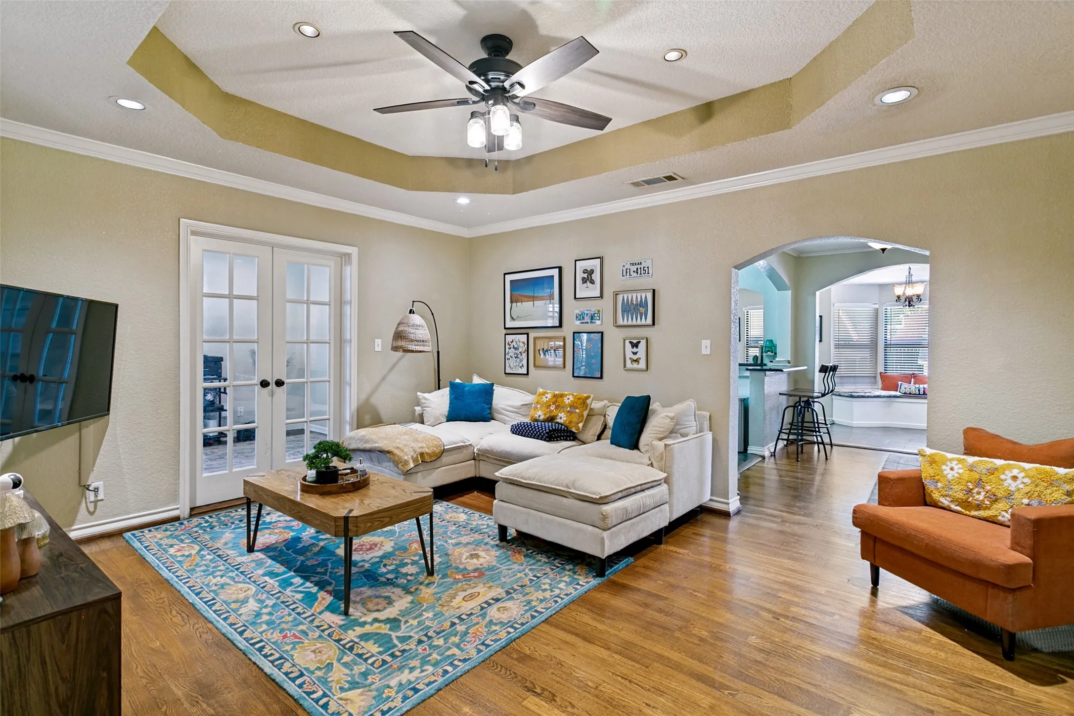 The living room has hardwood floors a coved ceiling and French doors lading to the office/third bedroom.
