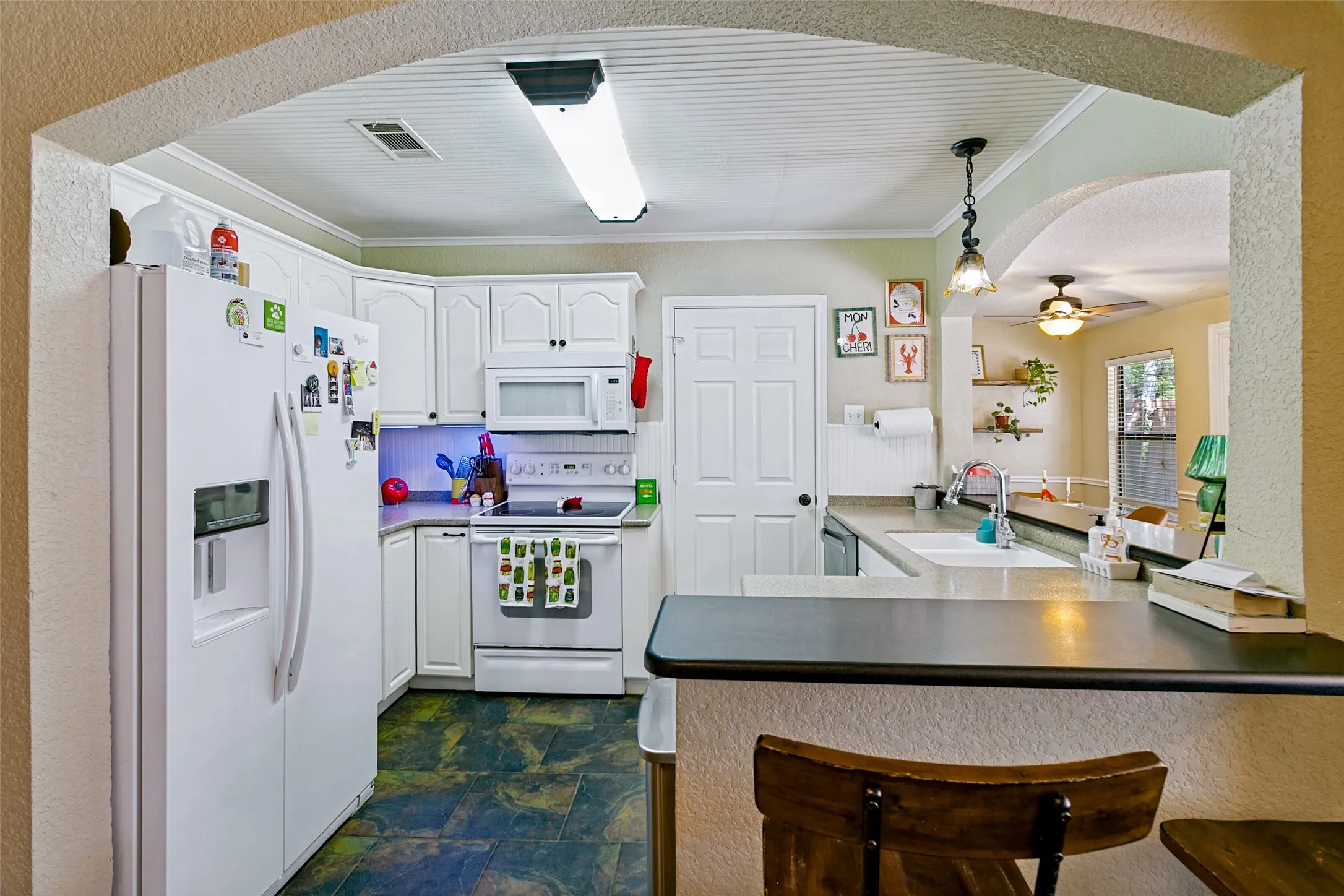 Note the arched doorway. The door leads to the large laundry room.