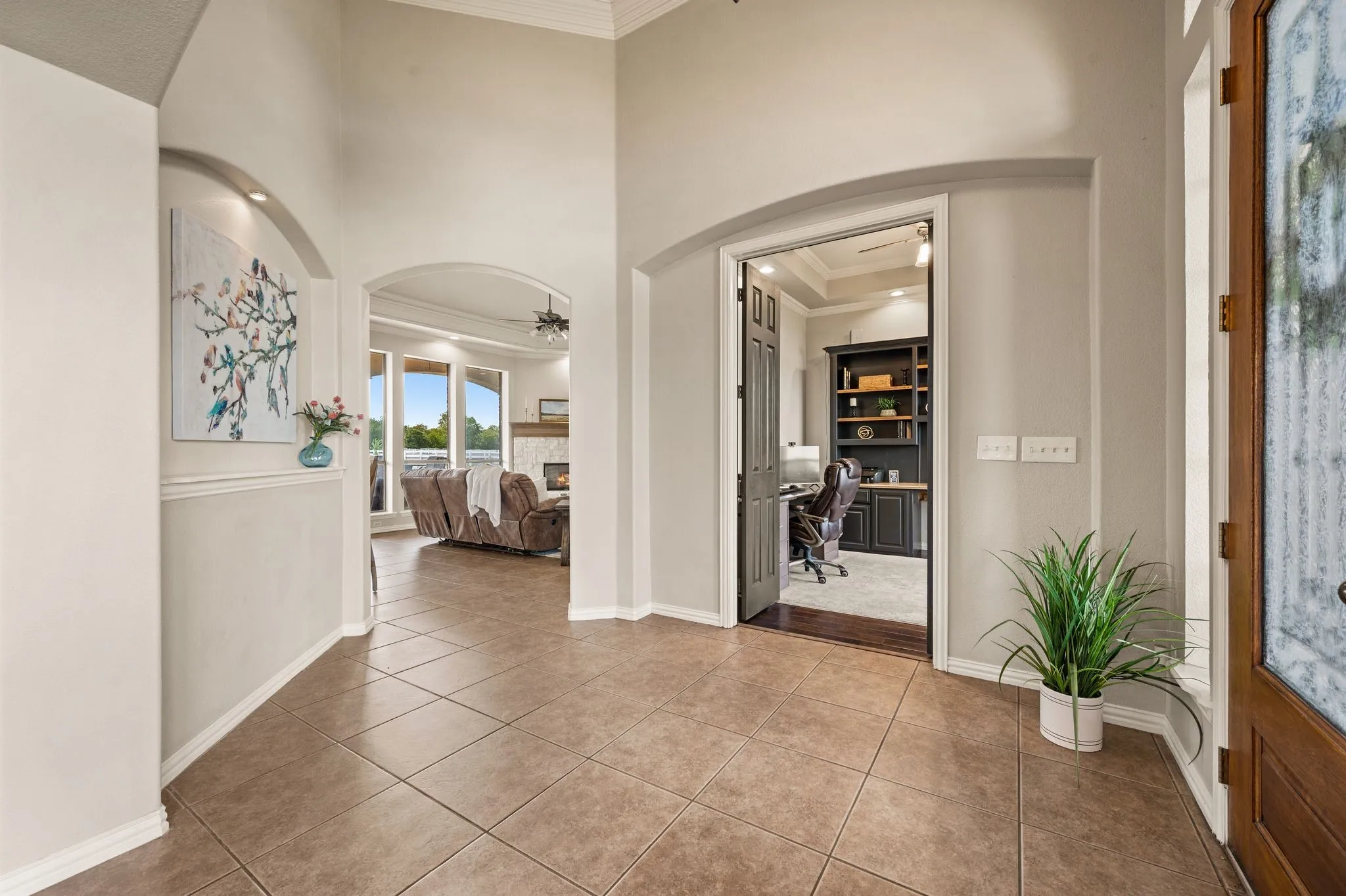arches, substantial millwork, detailed ceilings, stone fireplace, built-ins and a fantastic wood-trimmed office.