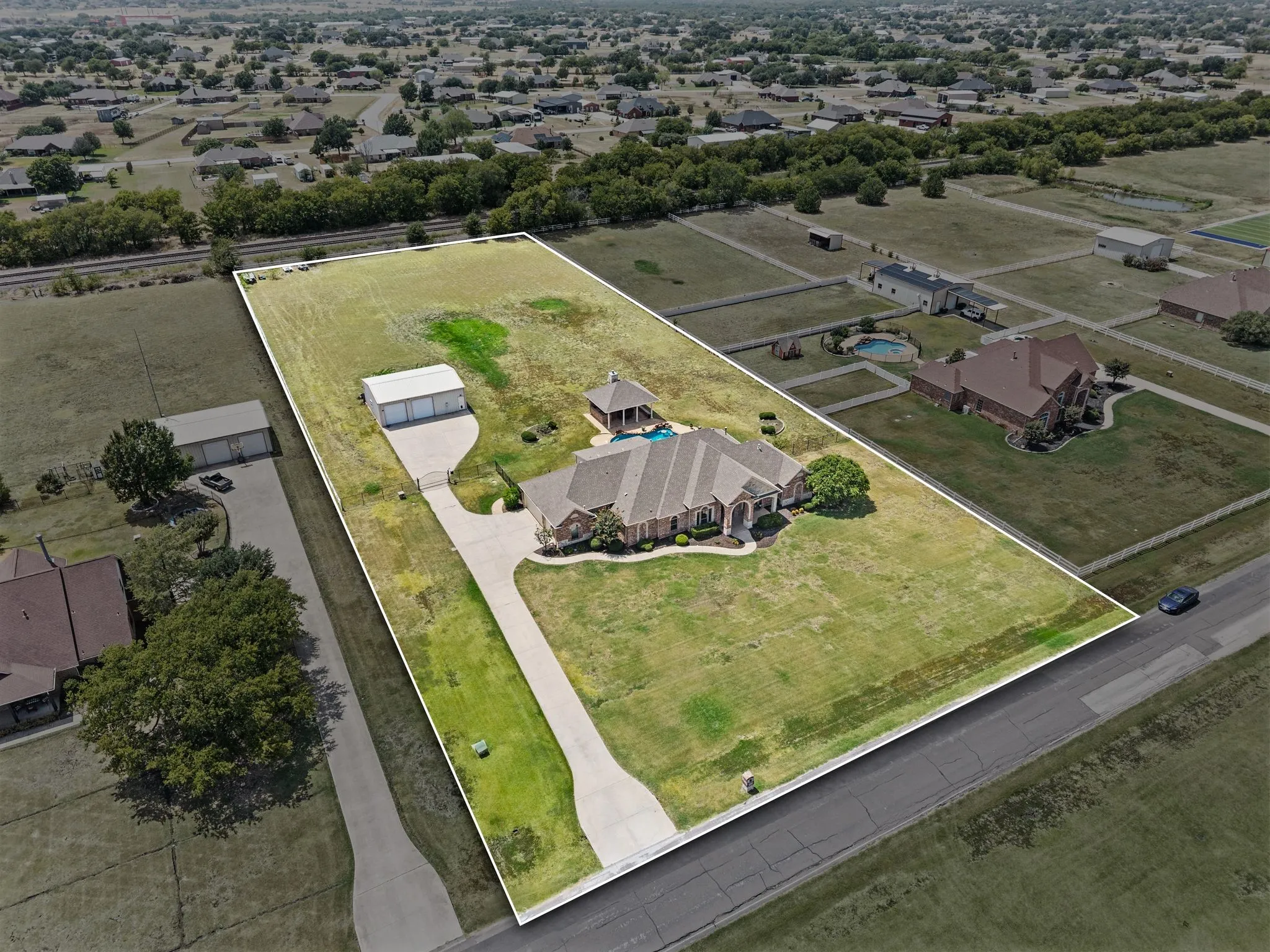 substantial custom home + resort-like outdoor living + serious shop + acreage.
