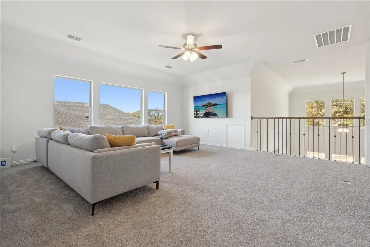 Expansive carpeted loft space featuring multiple windows