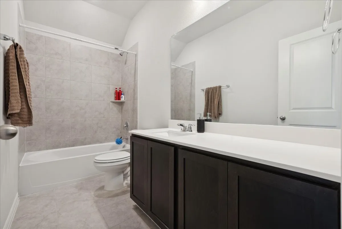 Bathroom featuring a single vanity with dark wood-finish cabinetry and a white countertop