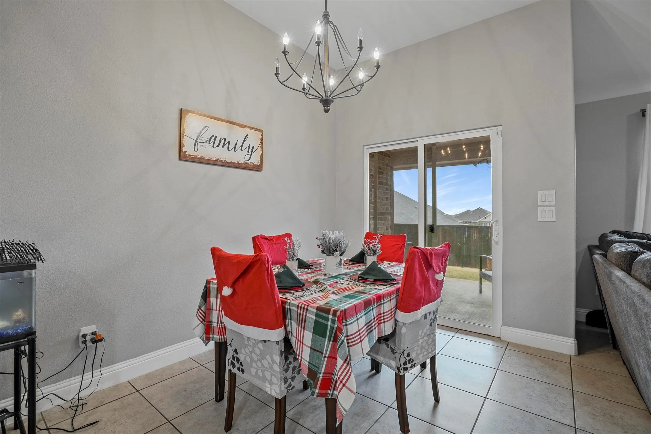 Dining area featuring tile flooring, a chandelier light fixture, and a sliding glass door providing outdoor access