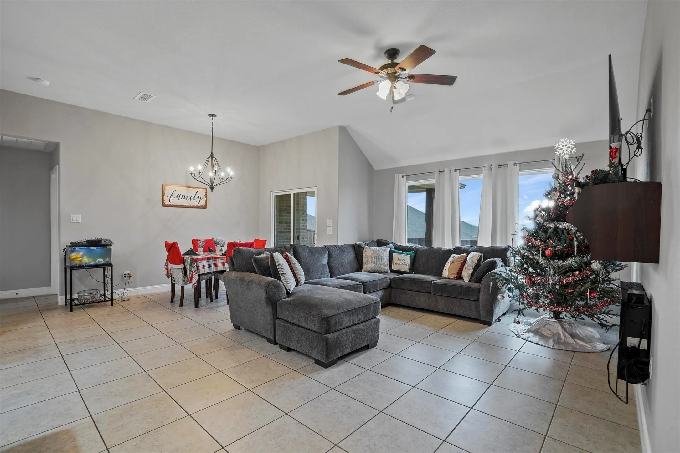 Spacious open-concept living area featuring light-toned tile flooring throughout