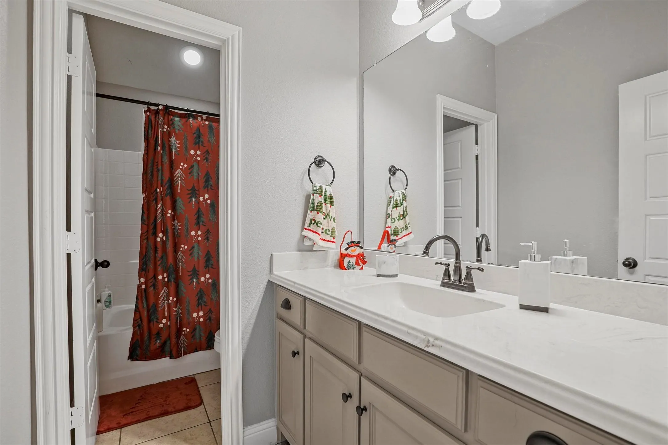 Bathroom vanity featuring a quartz-finish countertop with an integrated sink and a dark-finish faucet