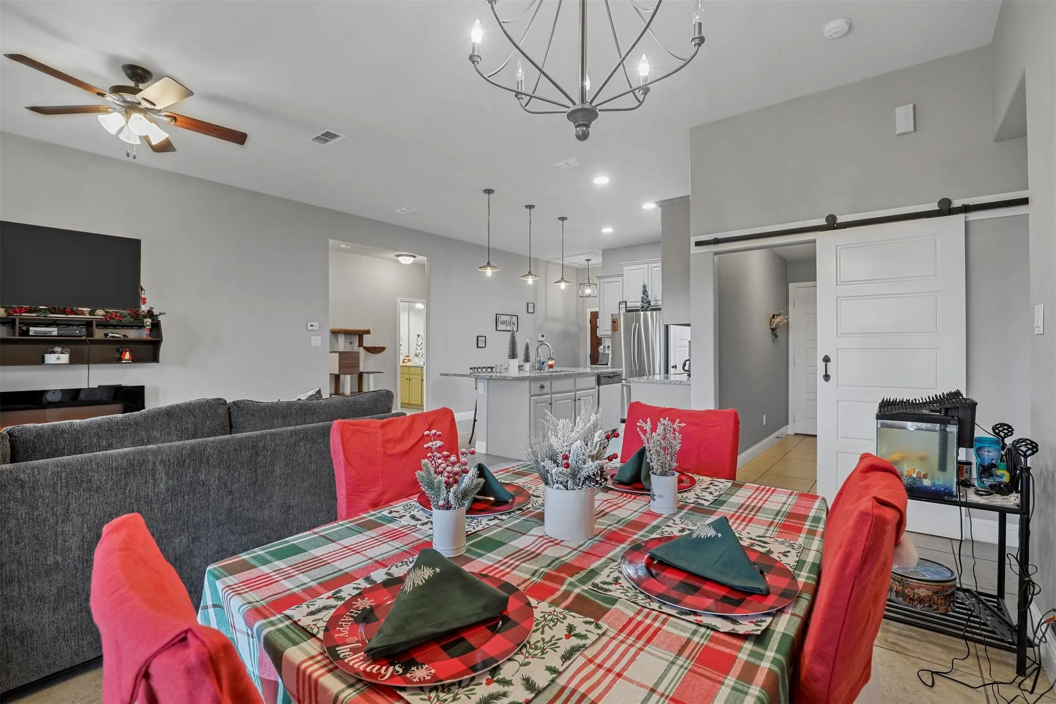 Open-concept living area featuring a decorative chandelier, a ceiling fan, and recessed lighting