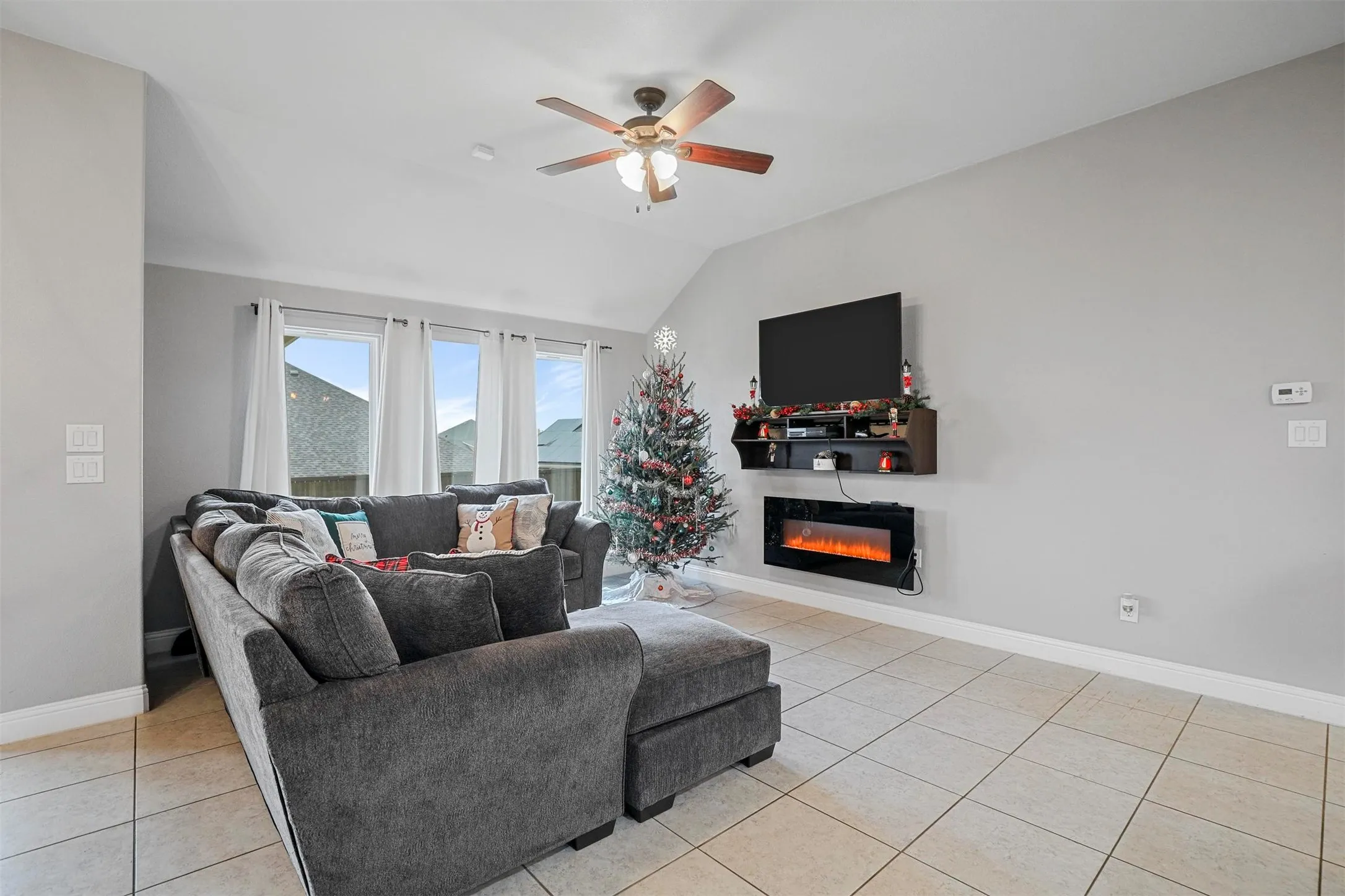 Spacious living area featuring light gray walls and tiled flooring