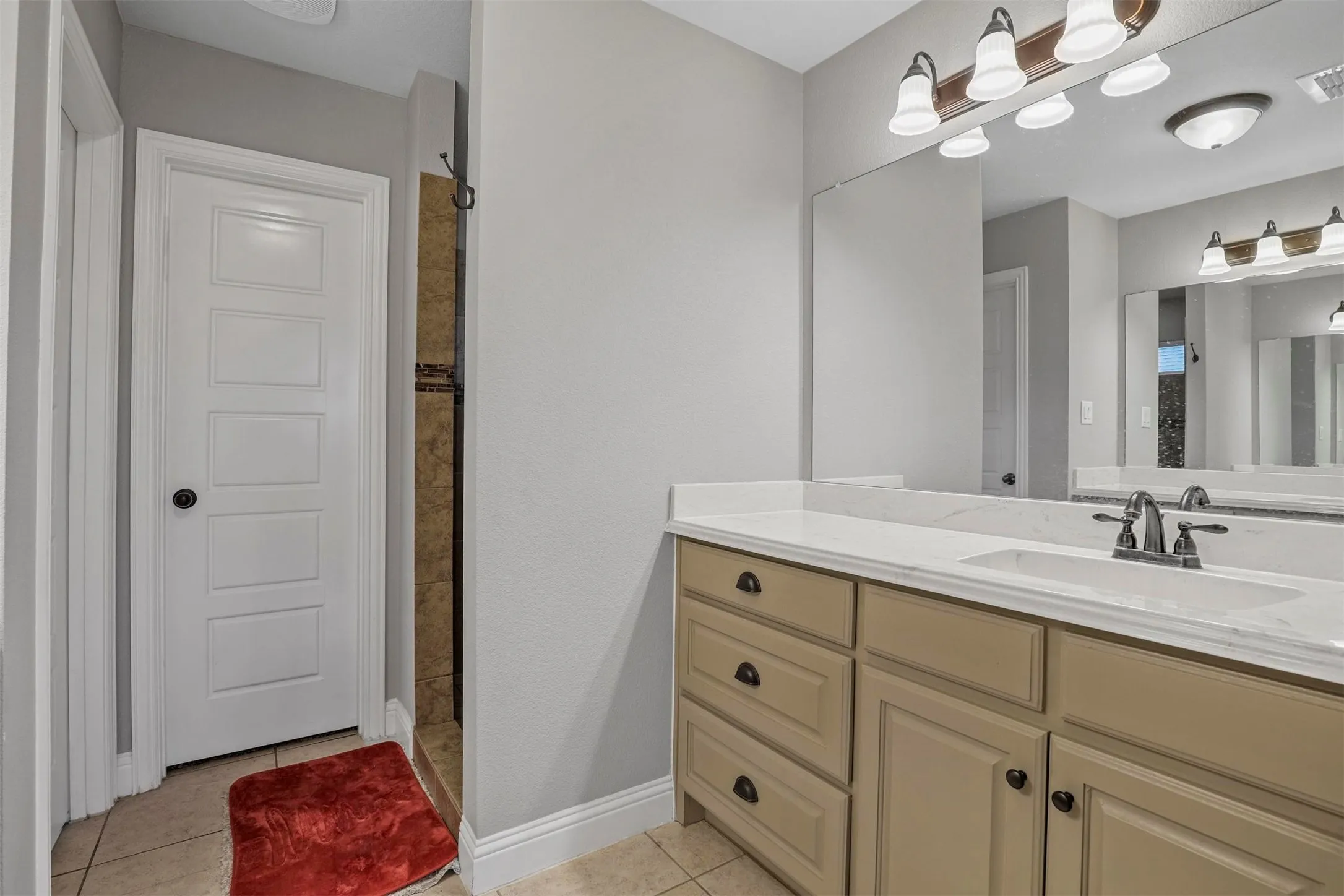 Bathroom vanity with a light-colored countertop, integrated rectangular sink, and dual-handle faucet