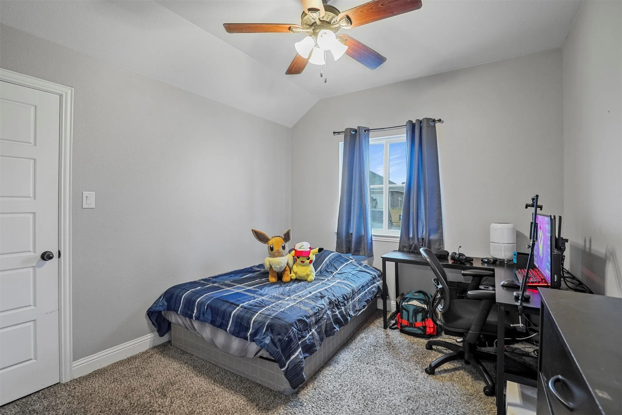 Carpeted interior space featuring a five-panel door, baseboards, and a window with curtain rod